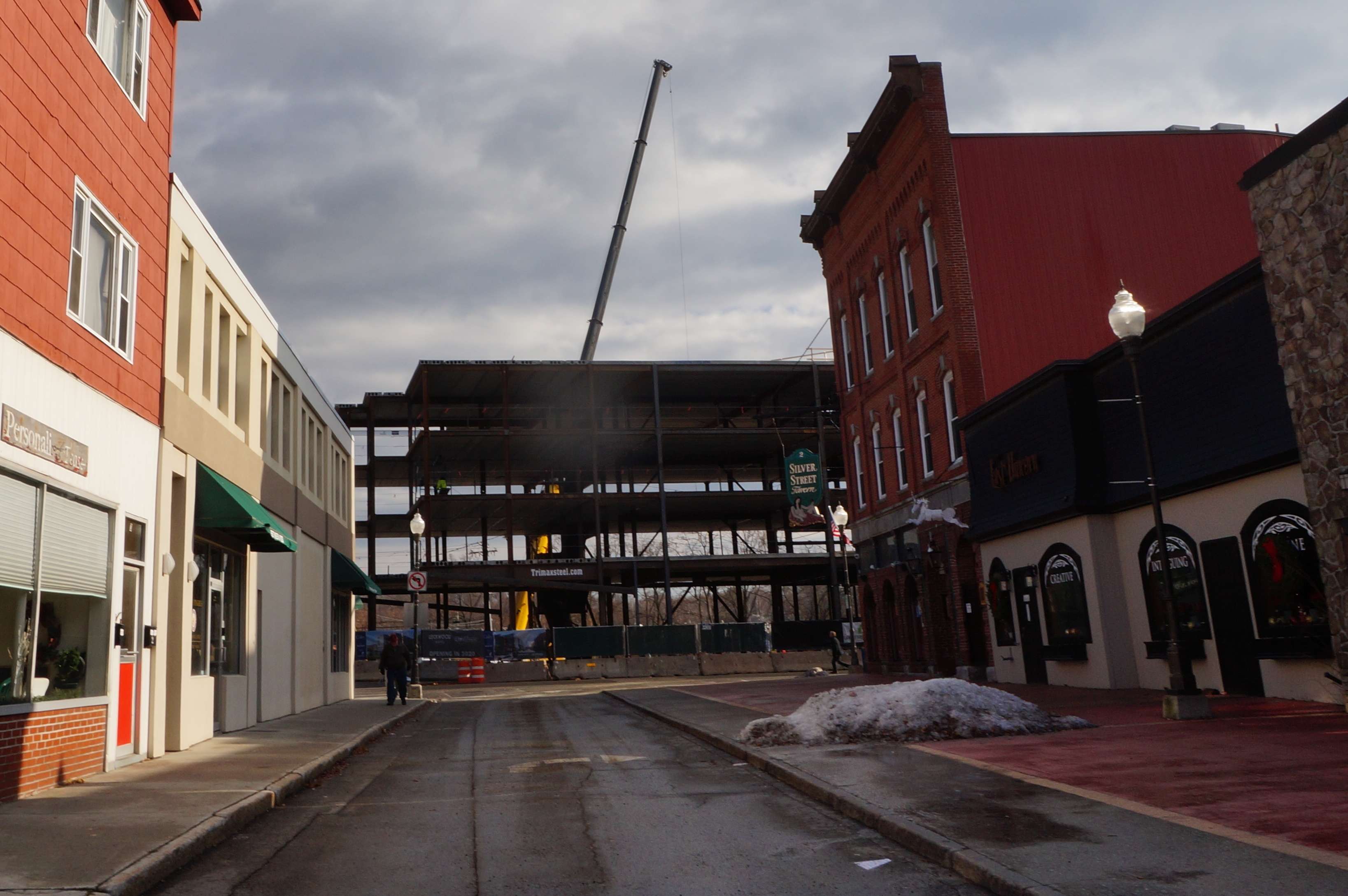 A downtown street with the steel frame of a building in the background