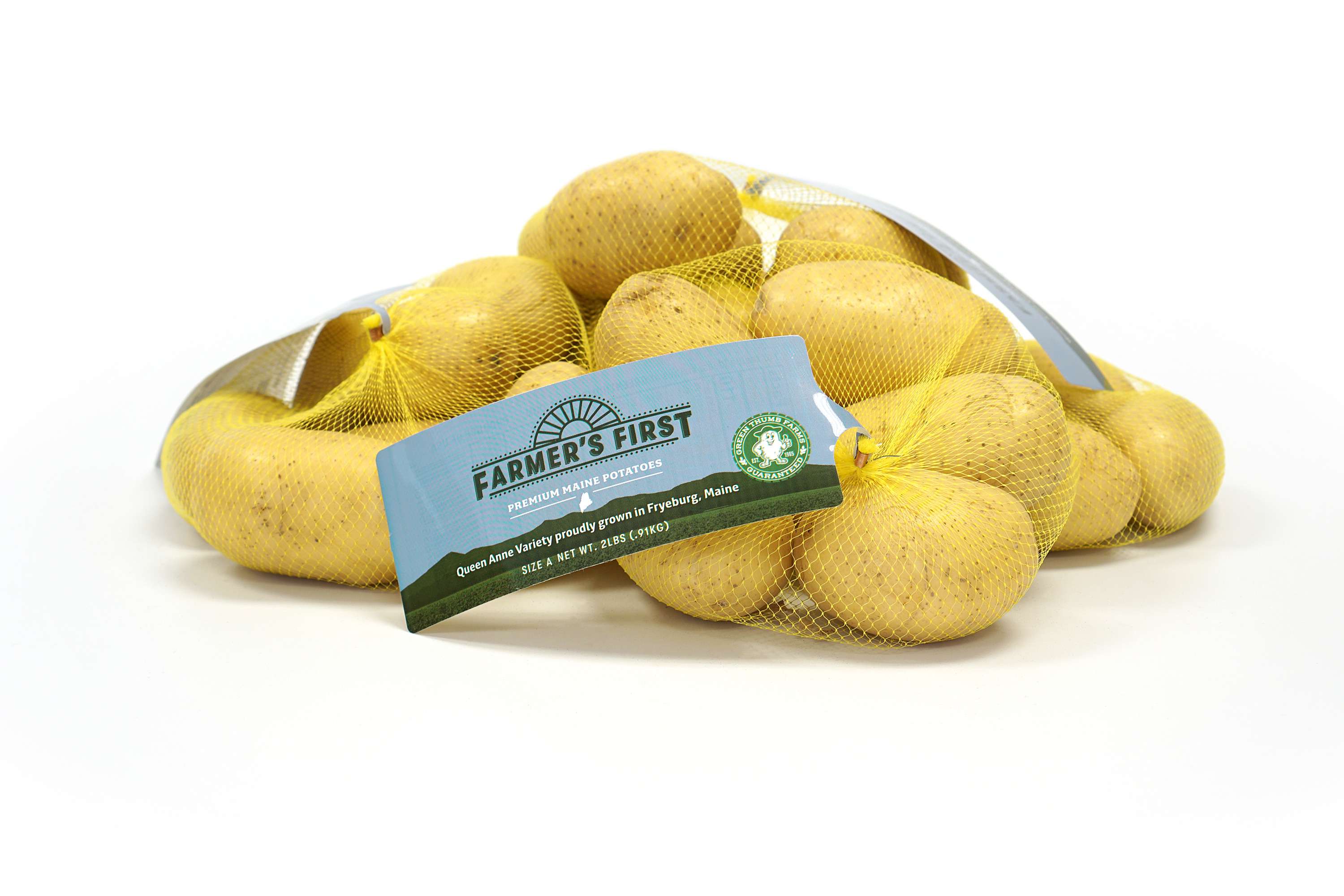 a mesh bag with yellow potatoes in in and a tag that says Farmers First