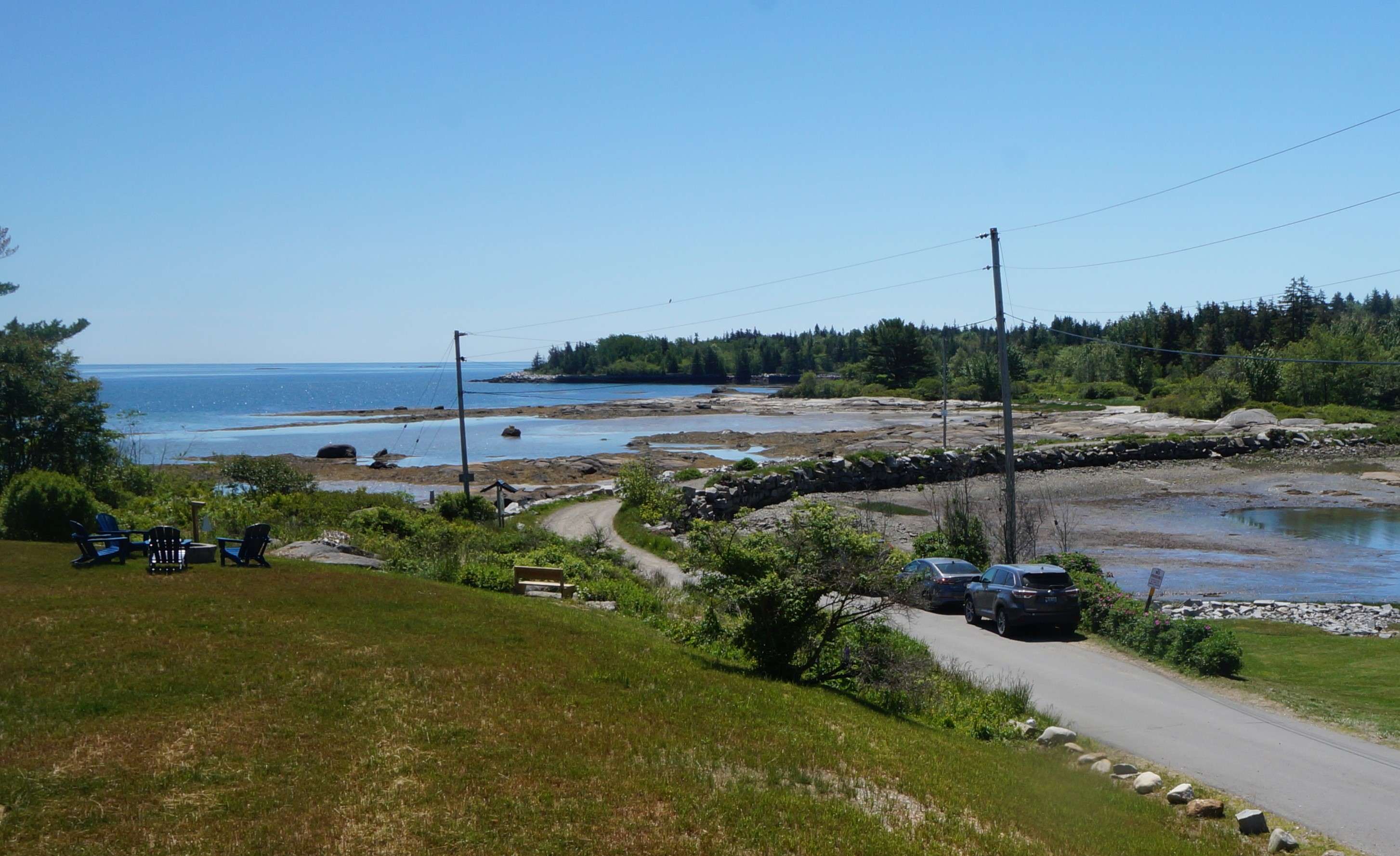 A lawn overlooking a causeway to an ocean island