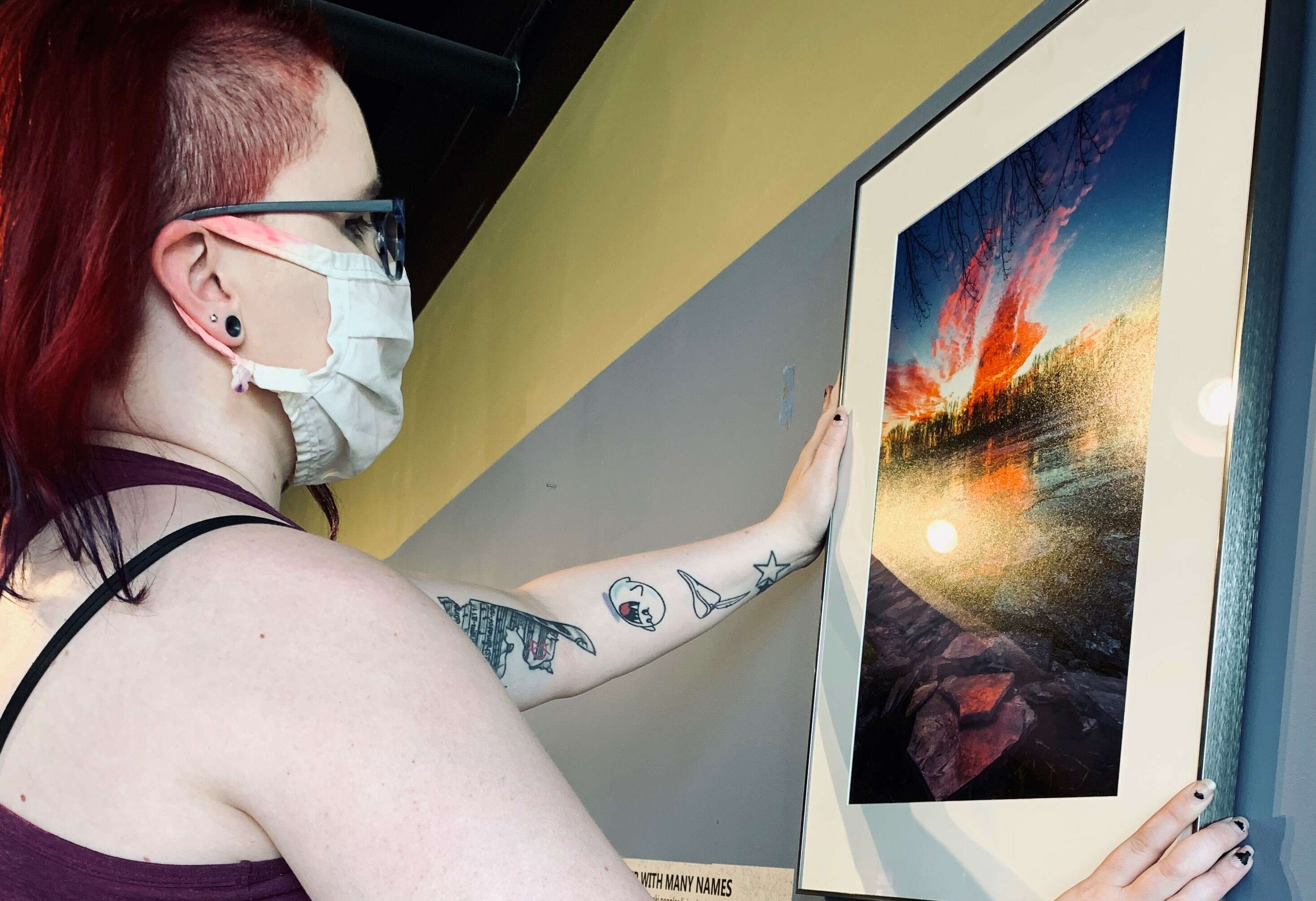 A young woman hanging a photograph on a wall