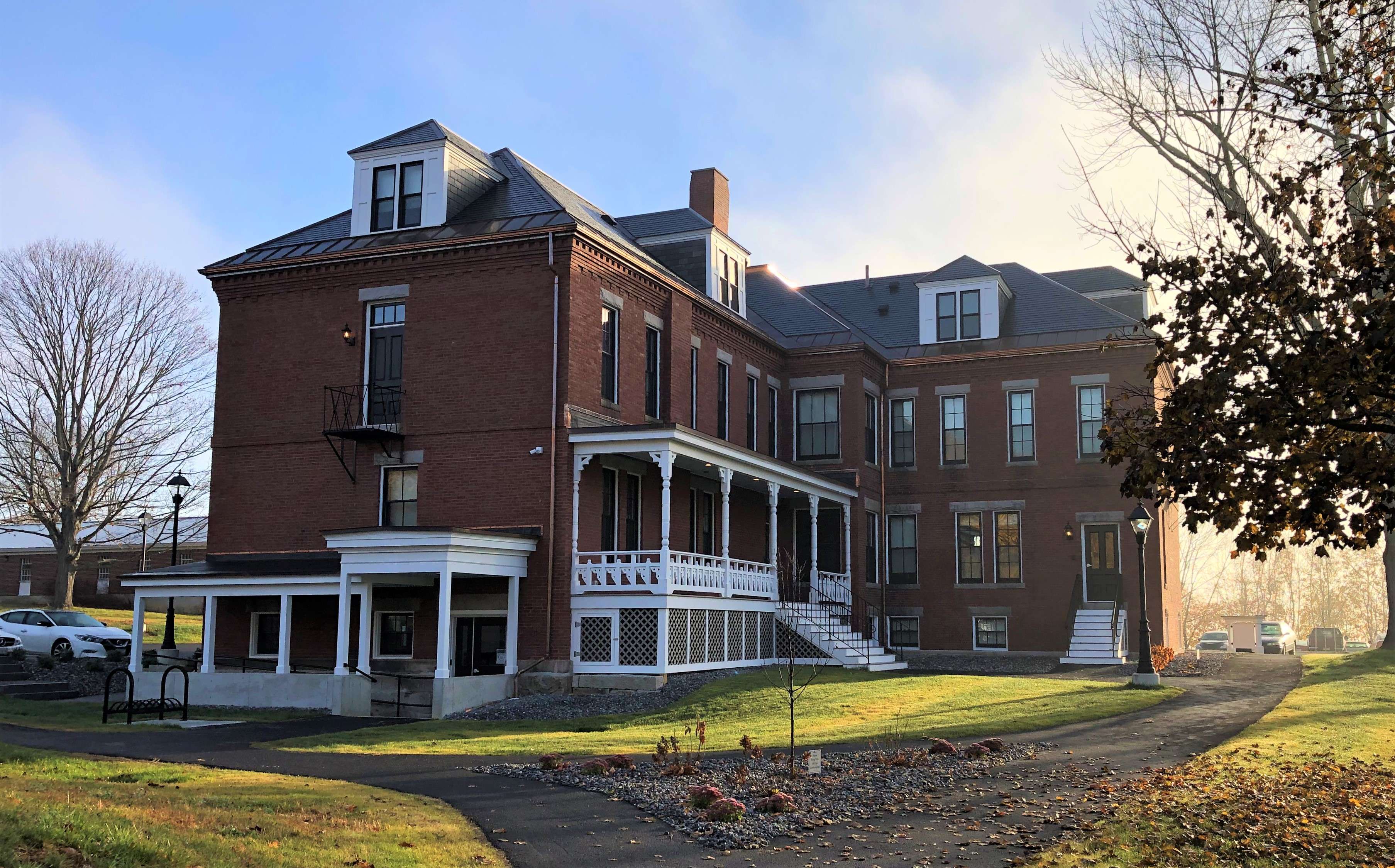 A 19th century three-story brick building with white trimmed porches