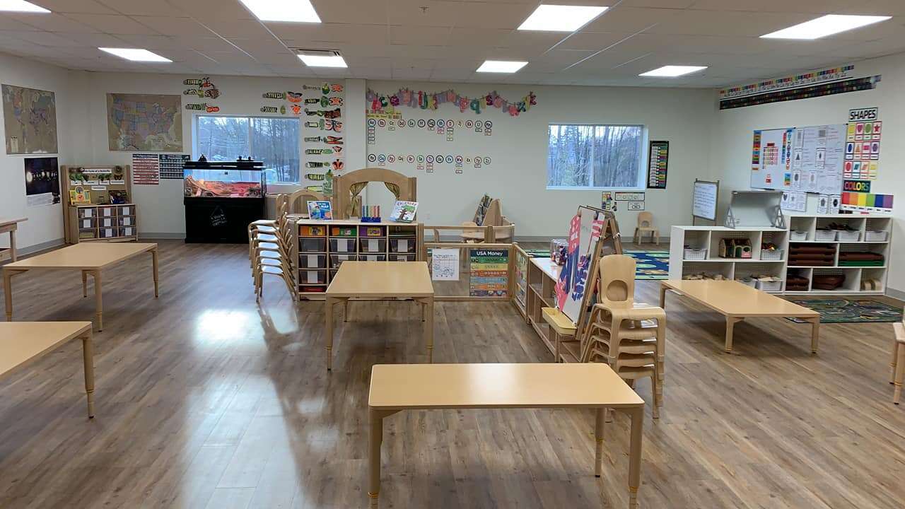 a classroom with small tables laminate floors and bright walls