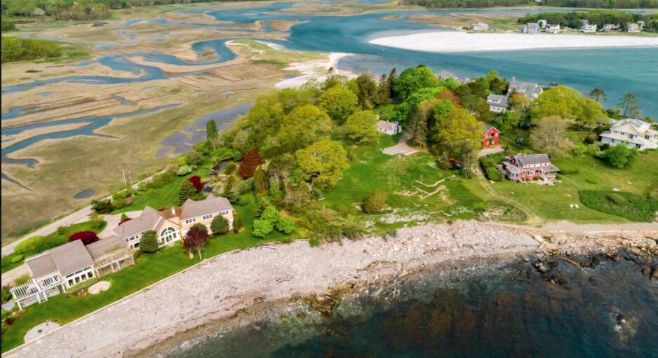 an aerial view of land, a river and the ocean with some large houses