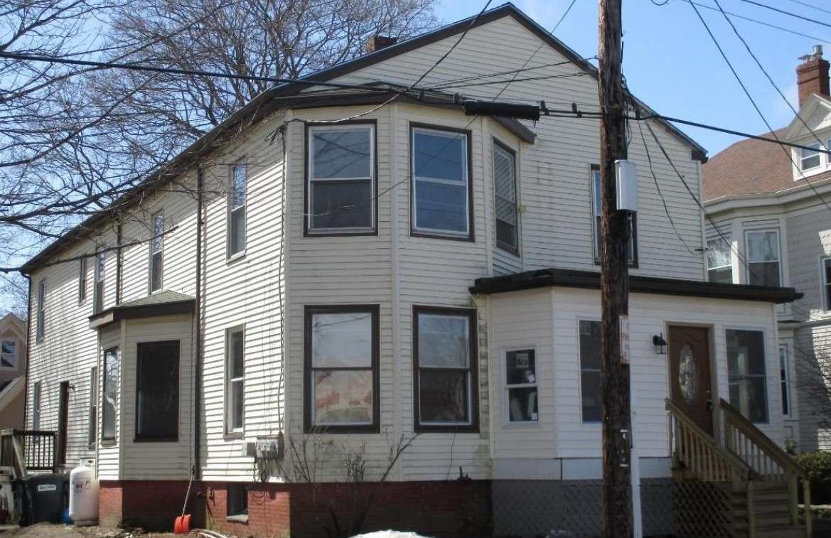 a large clapboard two-stroy building, beige with brown trim