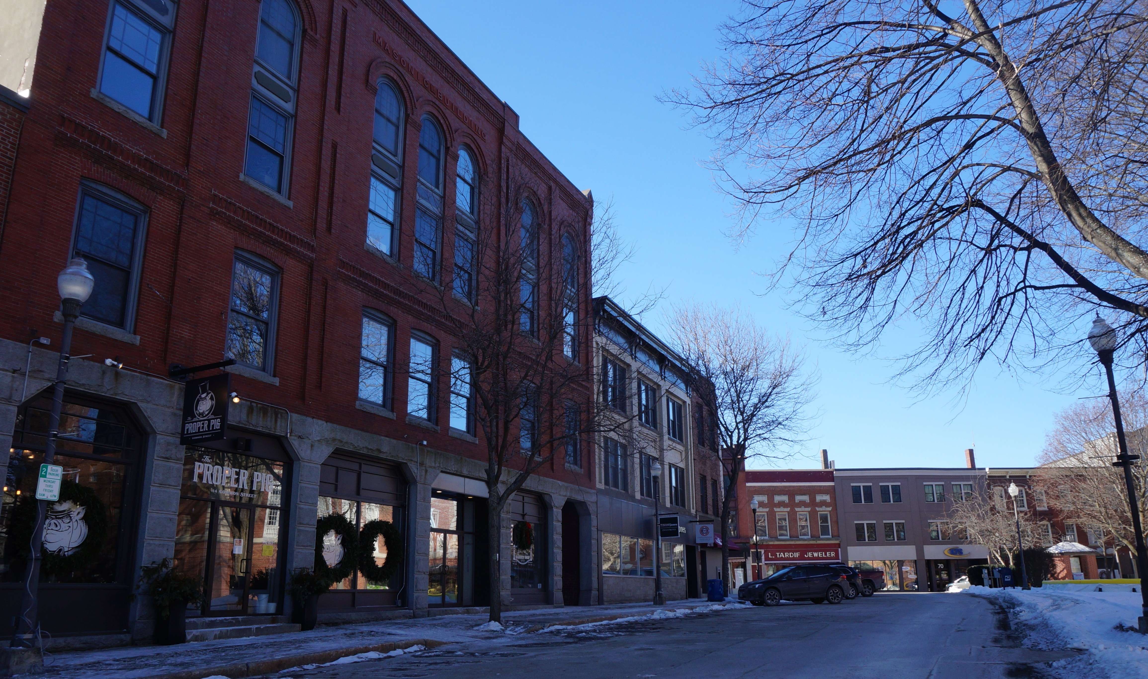 thee brich buildings line a narrow street