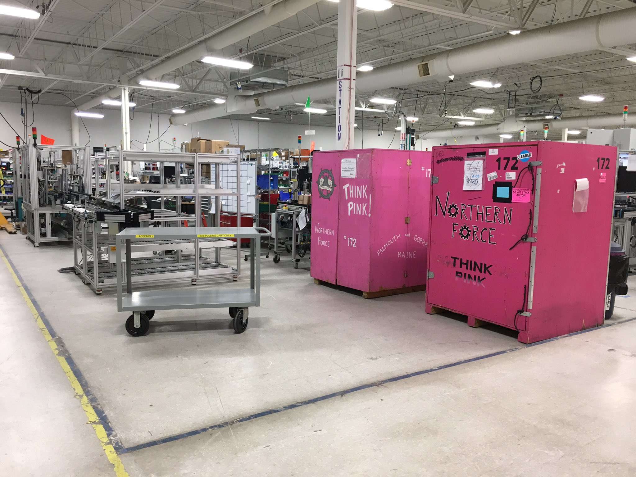 two large pink containers with northern force written on them, in an industrial room