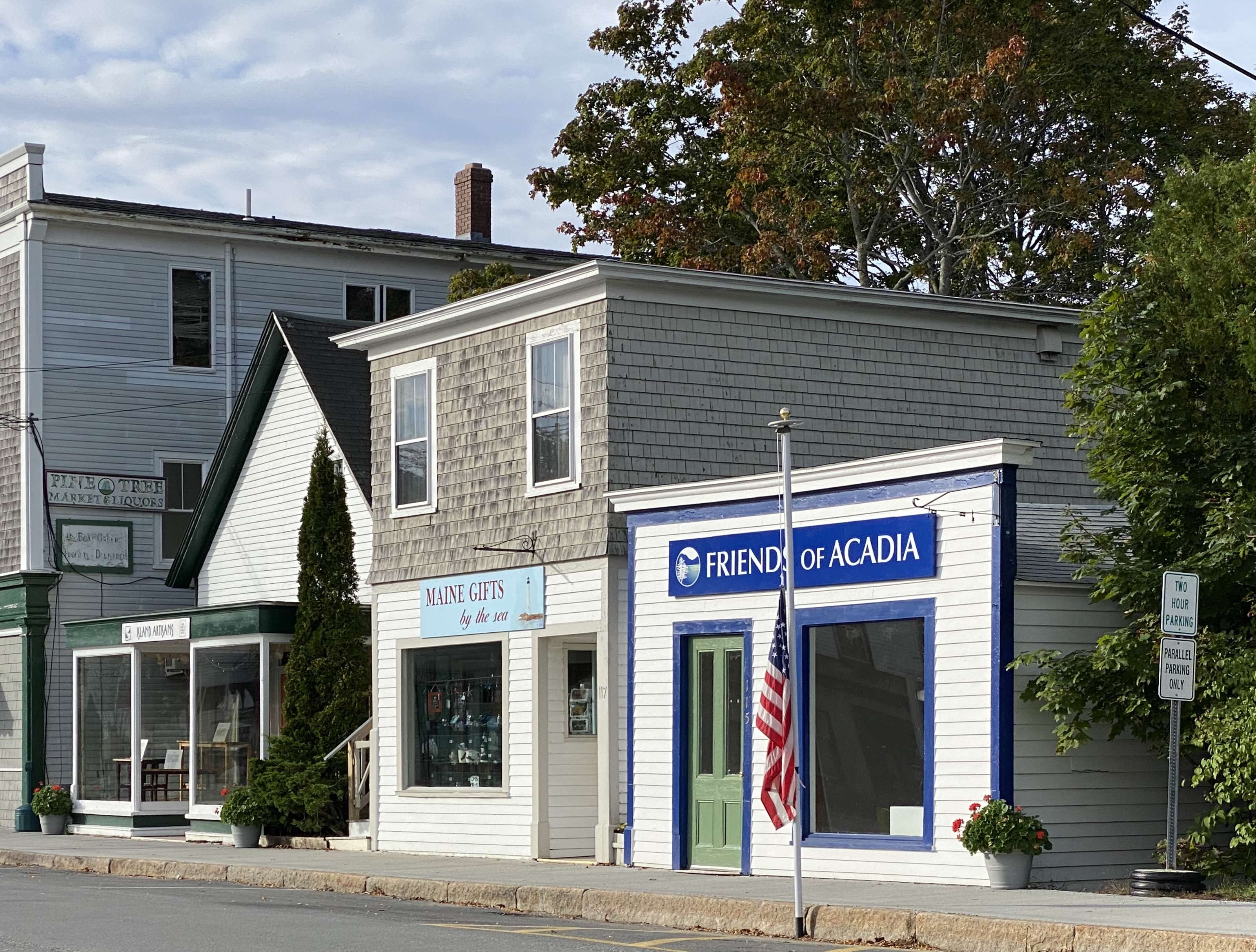 3 little buildings with signs and flag