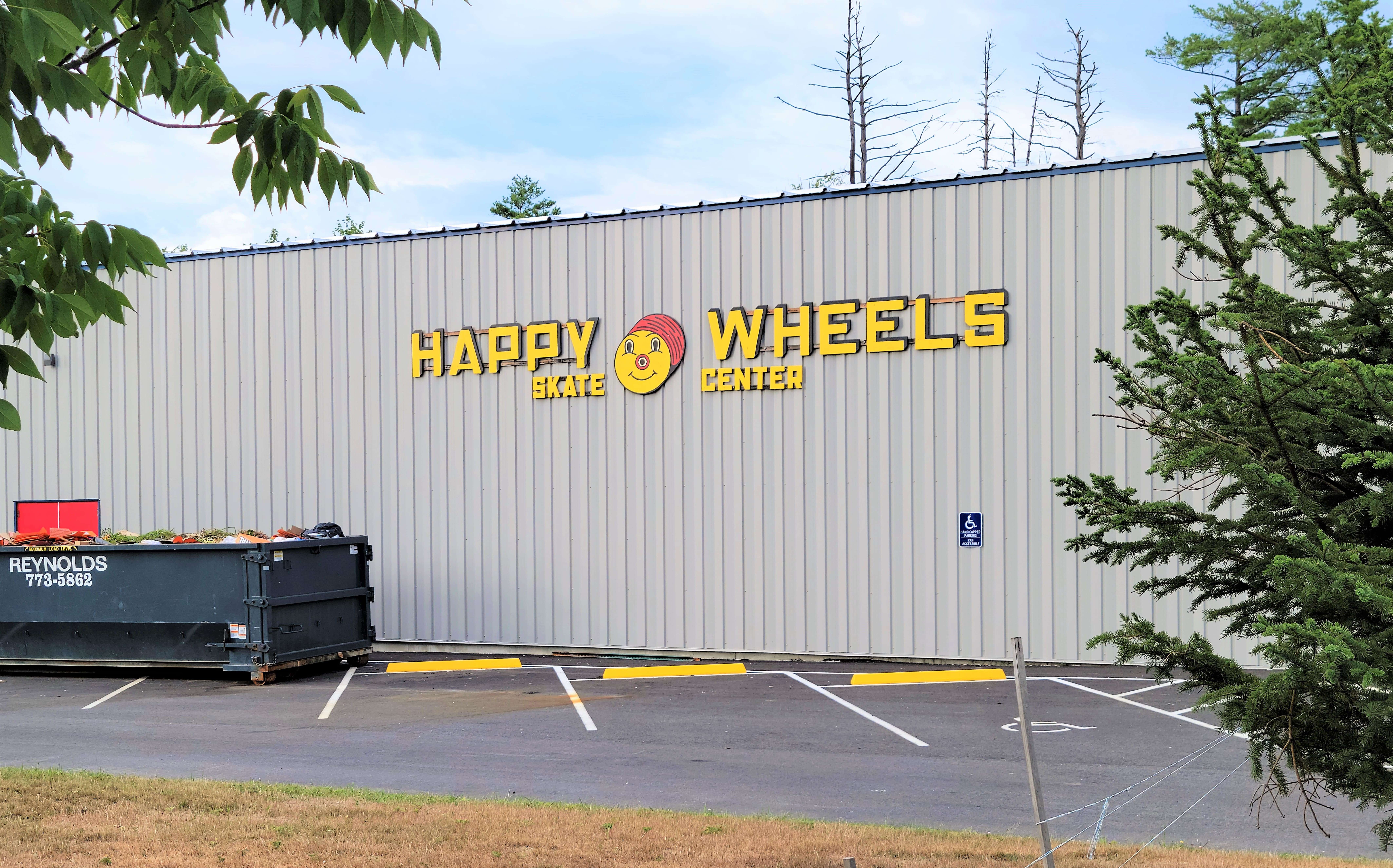 gray, industrial building with "Happy Wheels" sign