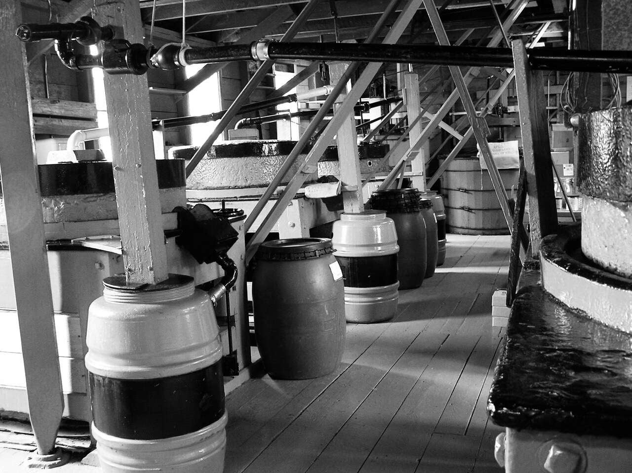black and white photo of barrels and grindstones