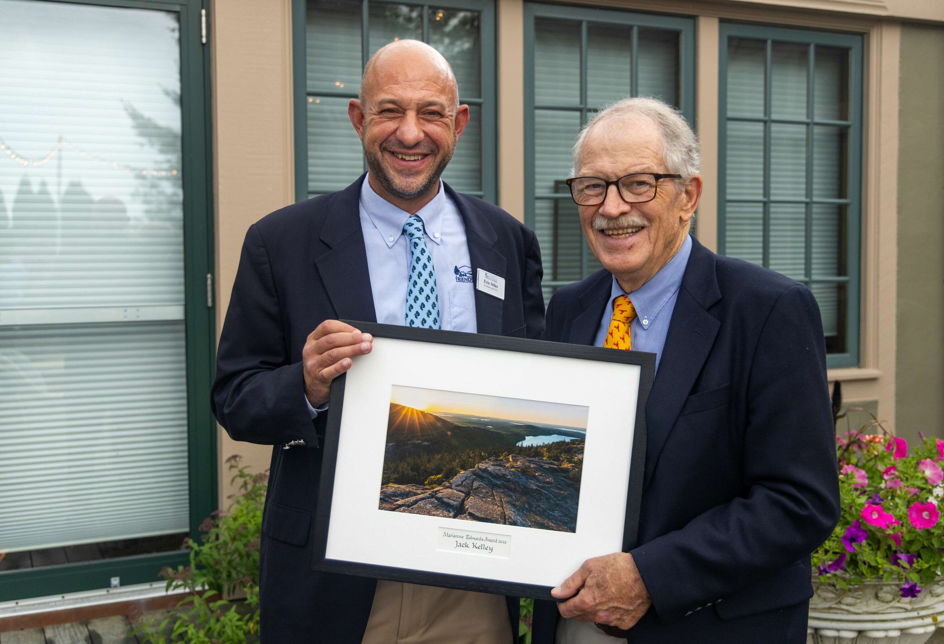 2 people smiling with framed photo