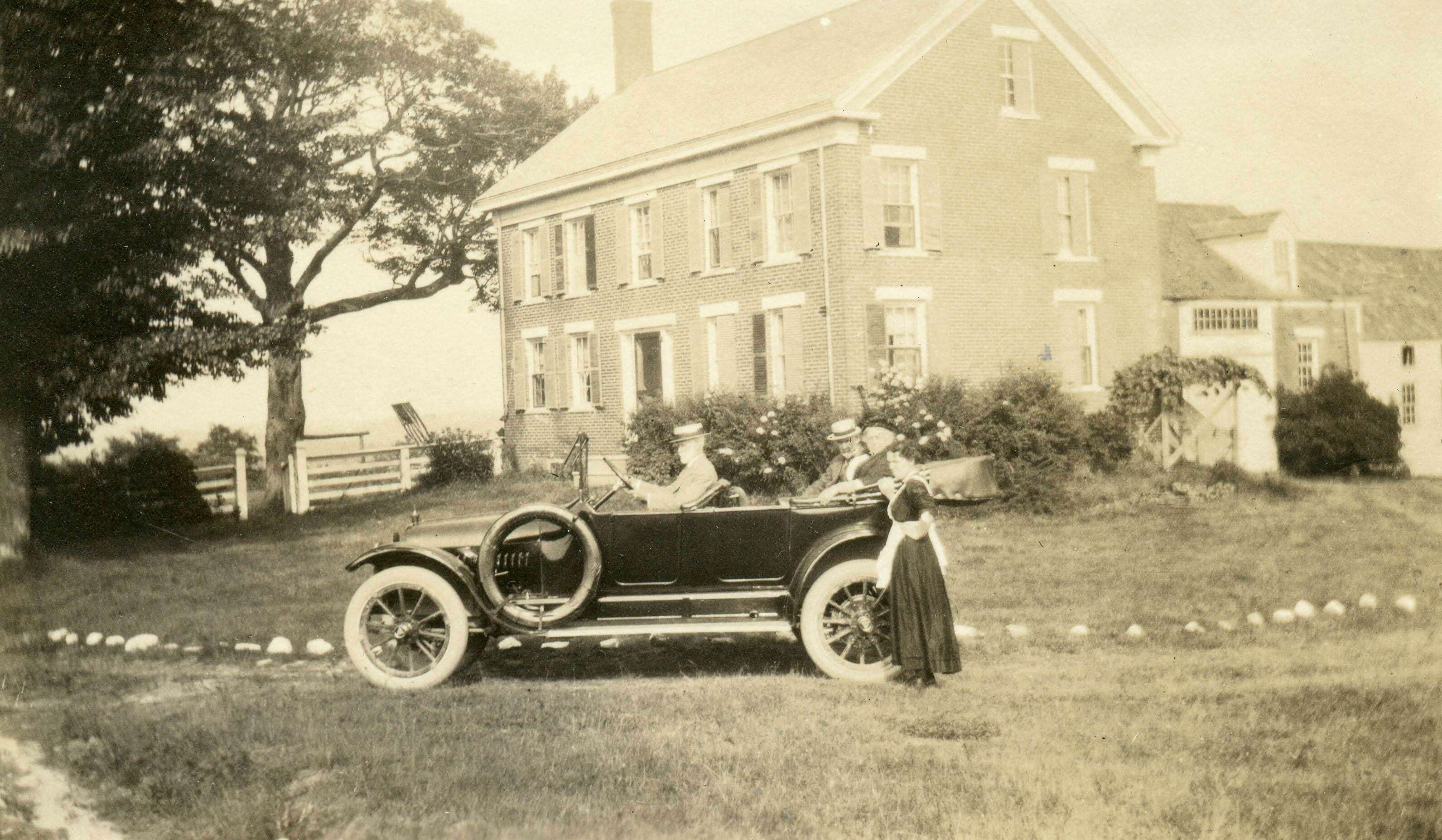 old photo of brick house and car