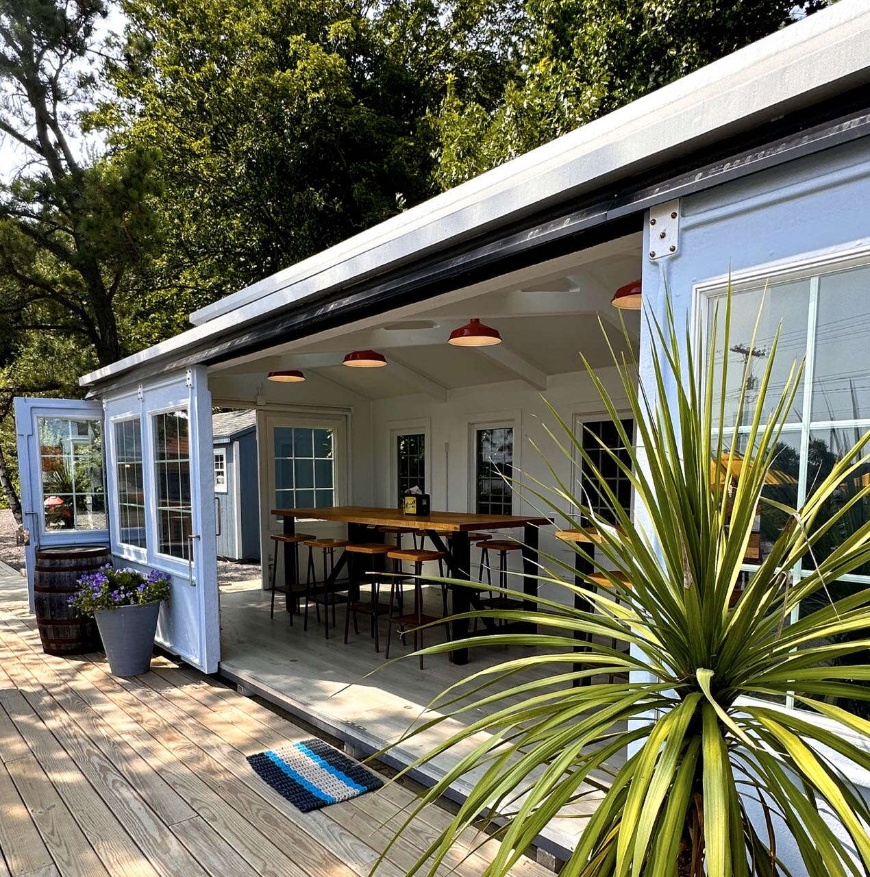 open walled structure with wood deck and plant