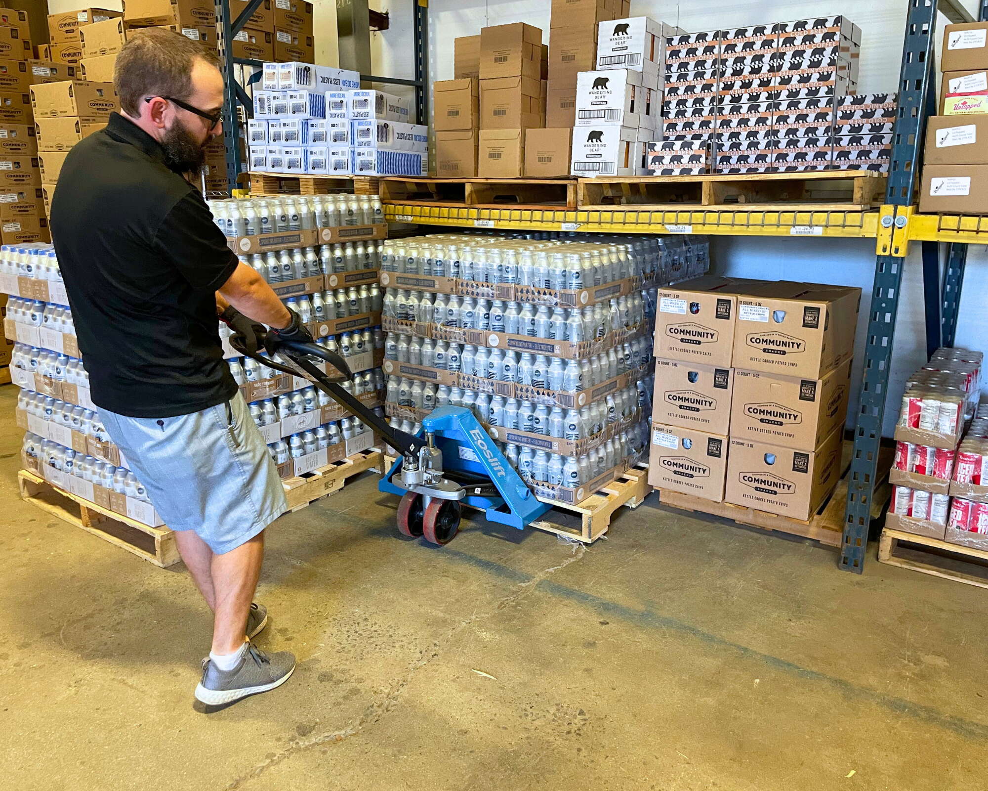 person with handcart and pallets of stuff