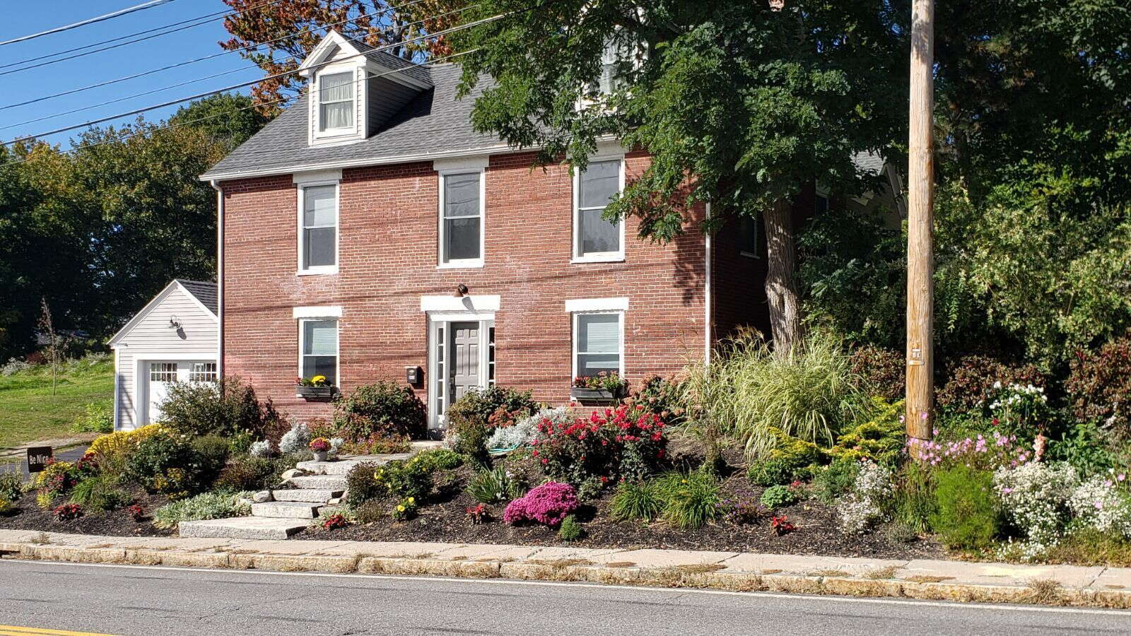 brick house with flowering bushes