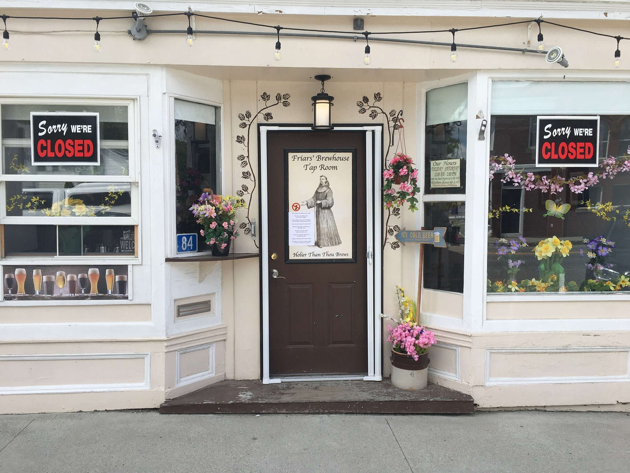 storefront with signs and flowers