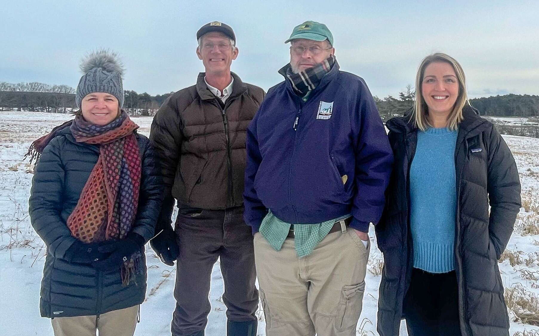 4 people standing outisde in the cold