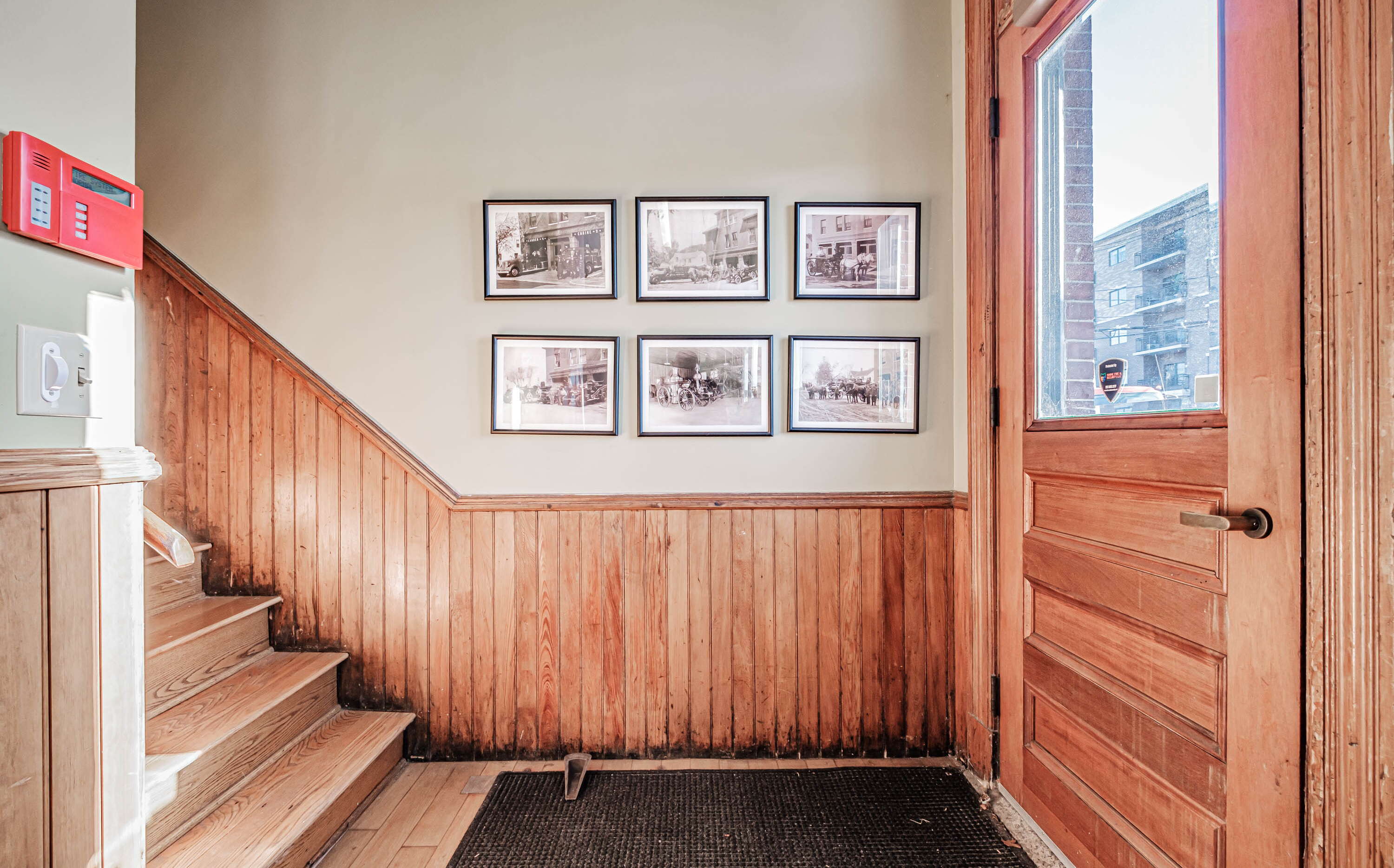 hall and stairs with woodwork and door and pictures