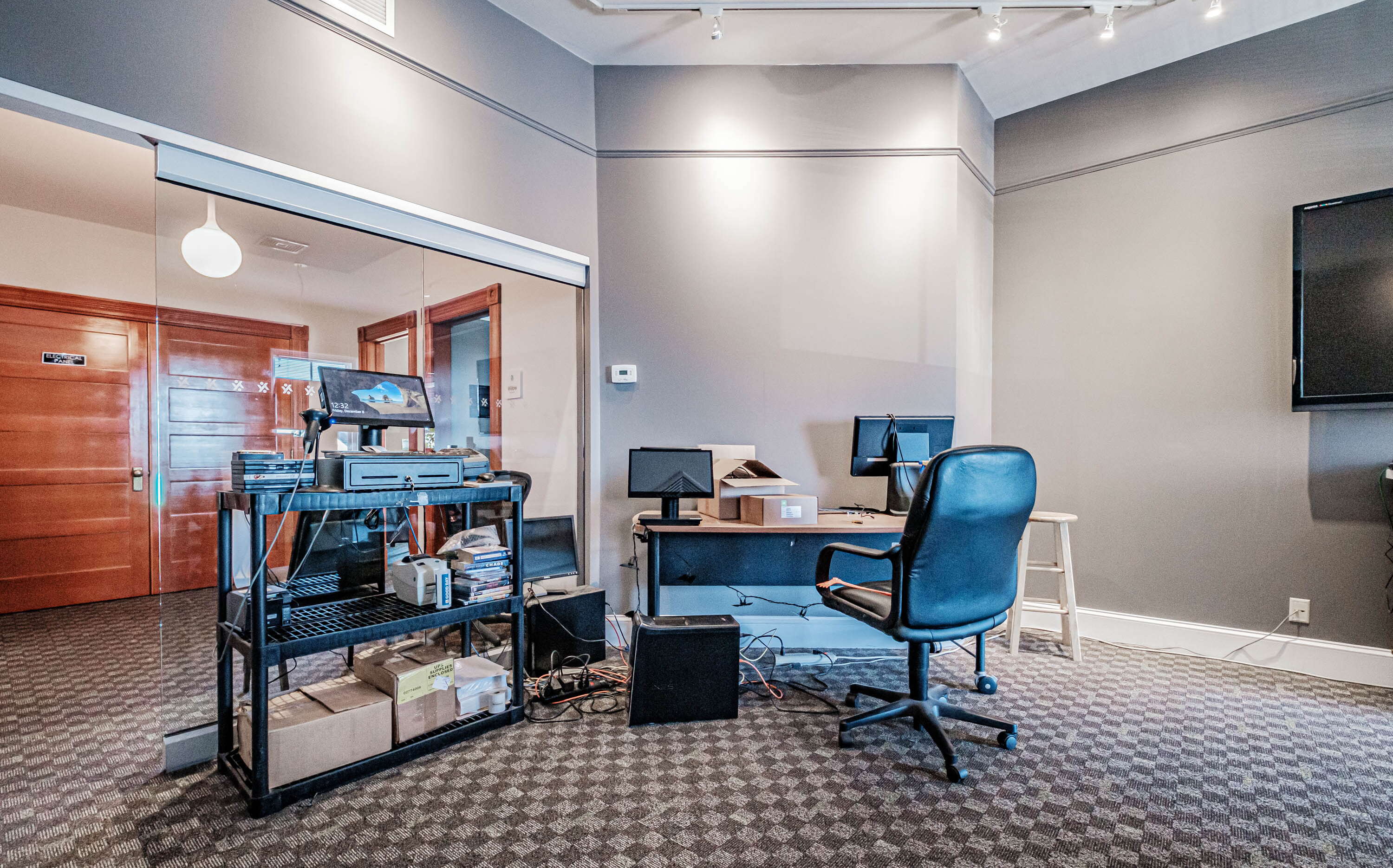 big space with rug, desks, chair, and shelves