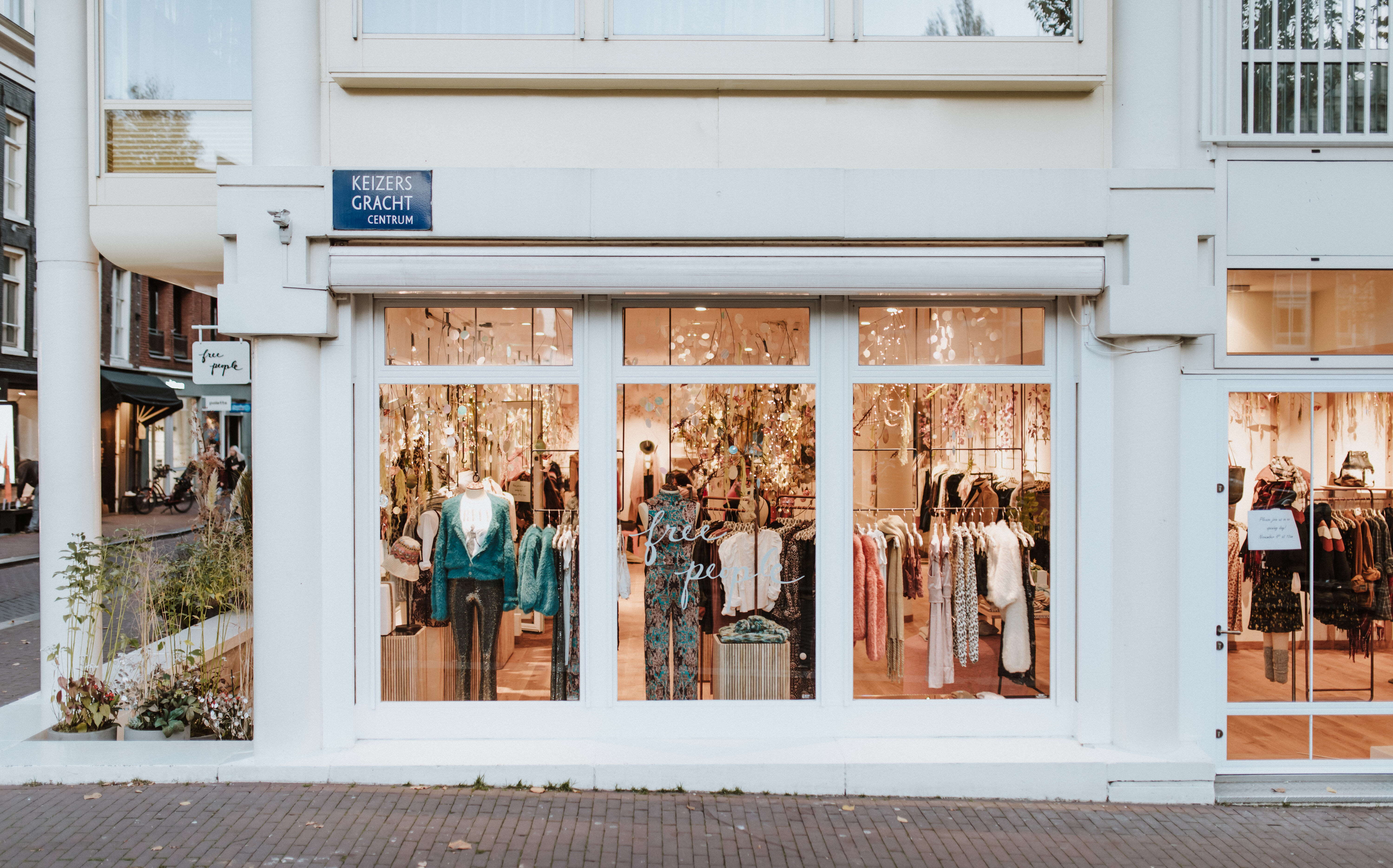 storefront with brick sidewalk and clothes in the windows