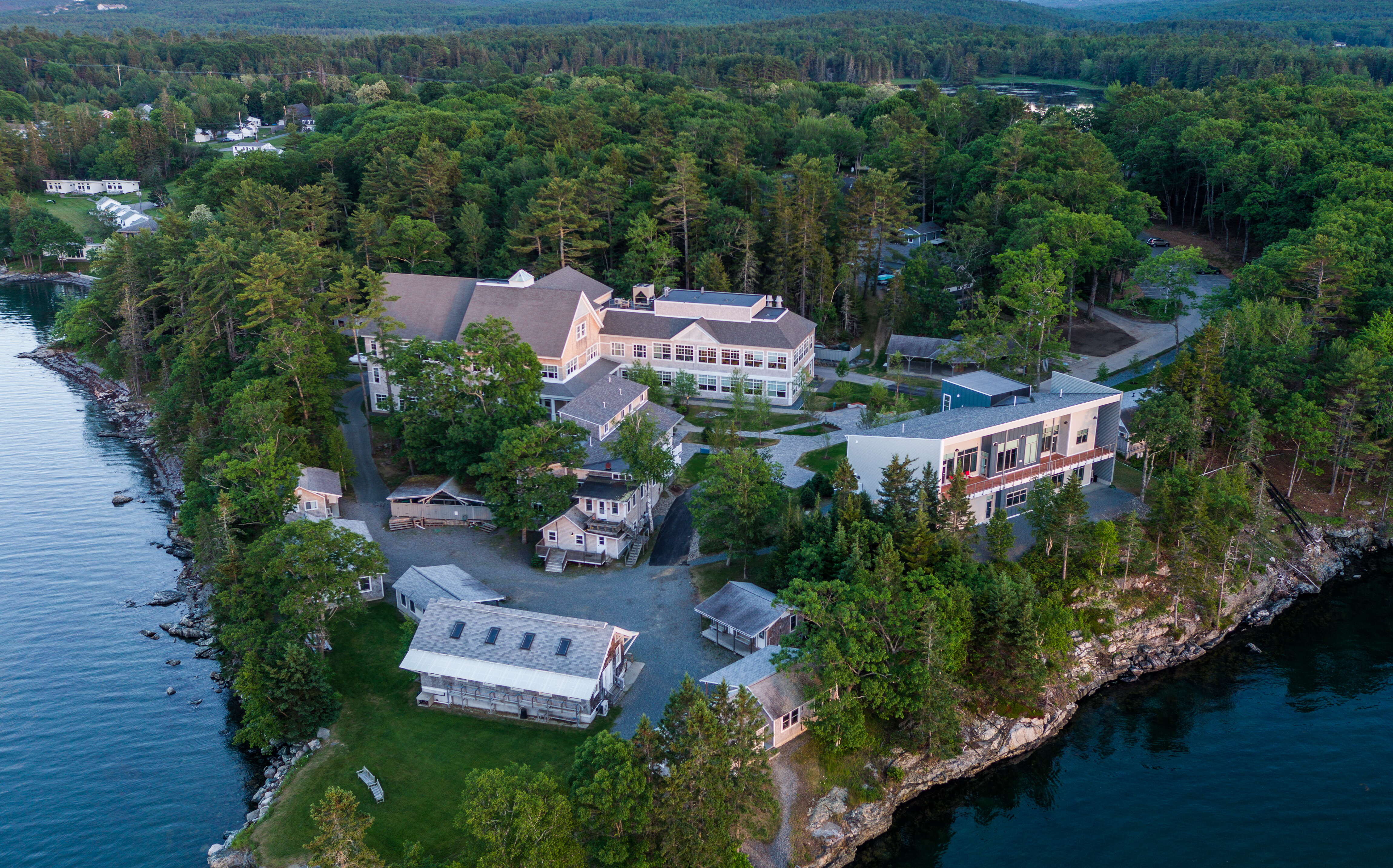 aerial of buildings and trees on peninsula with water