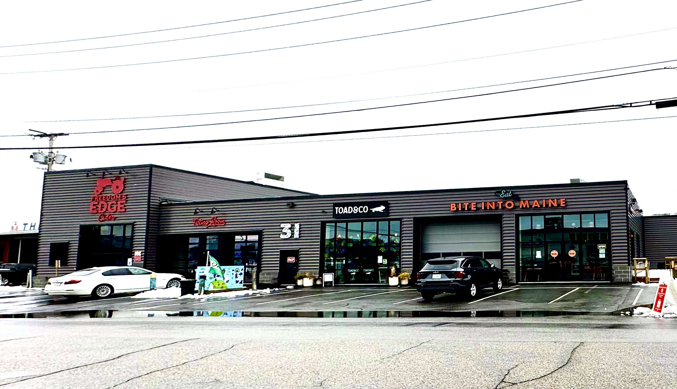 gray building with signs and cars