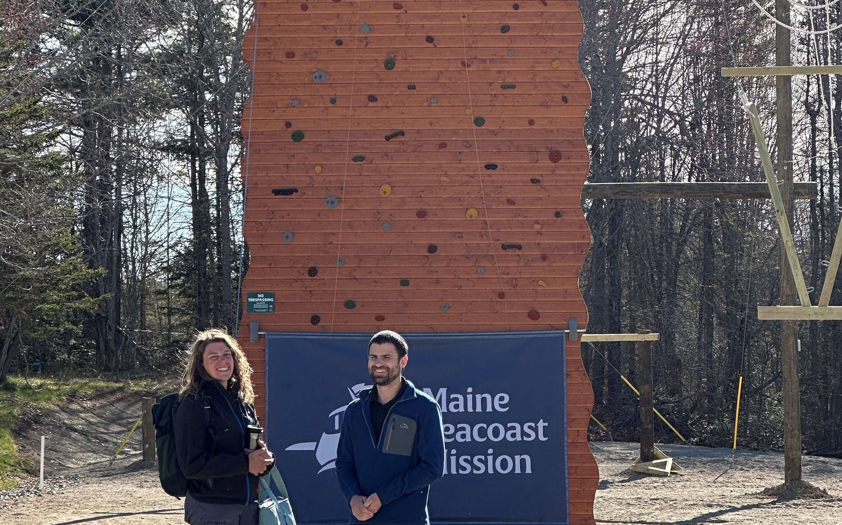 two people in front of partial wall