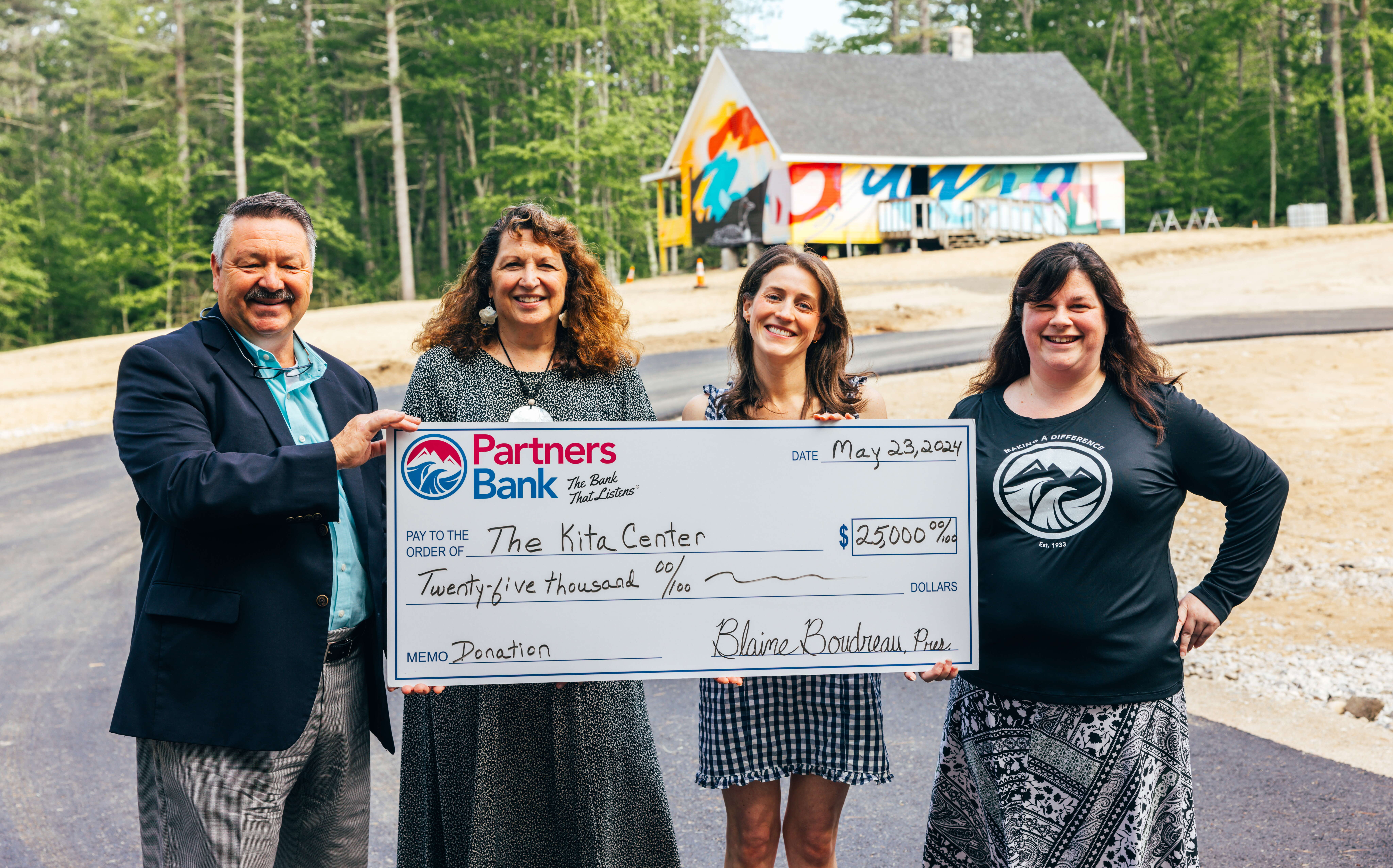 Four people pose with an oversize check for The Kita Center.