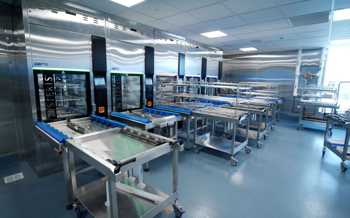 A room contains gleaming metal equipment and tables.