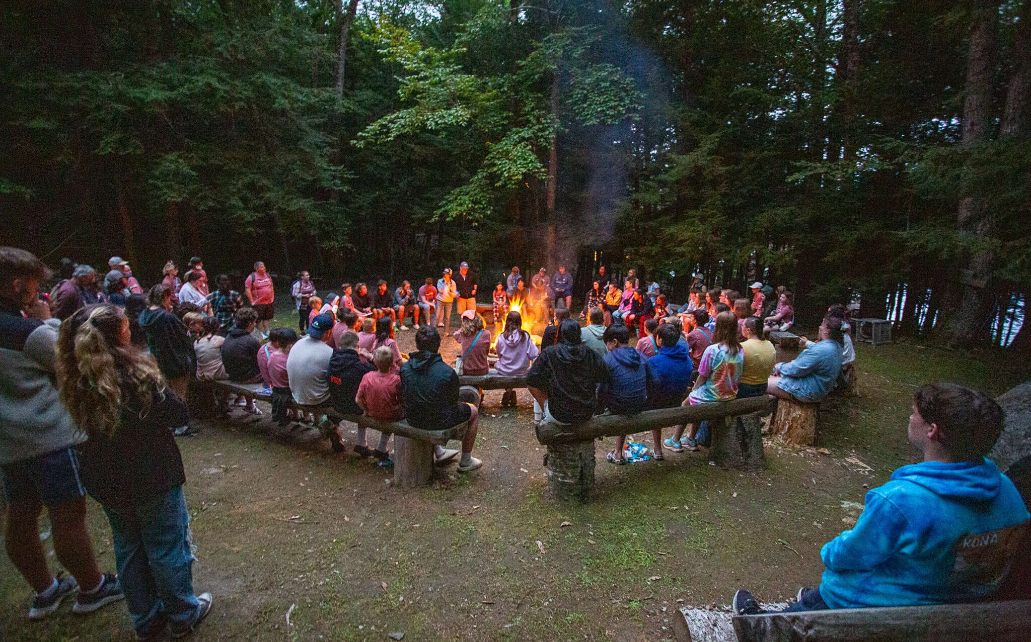 Campers at Camp Kita sit around a bonfire.