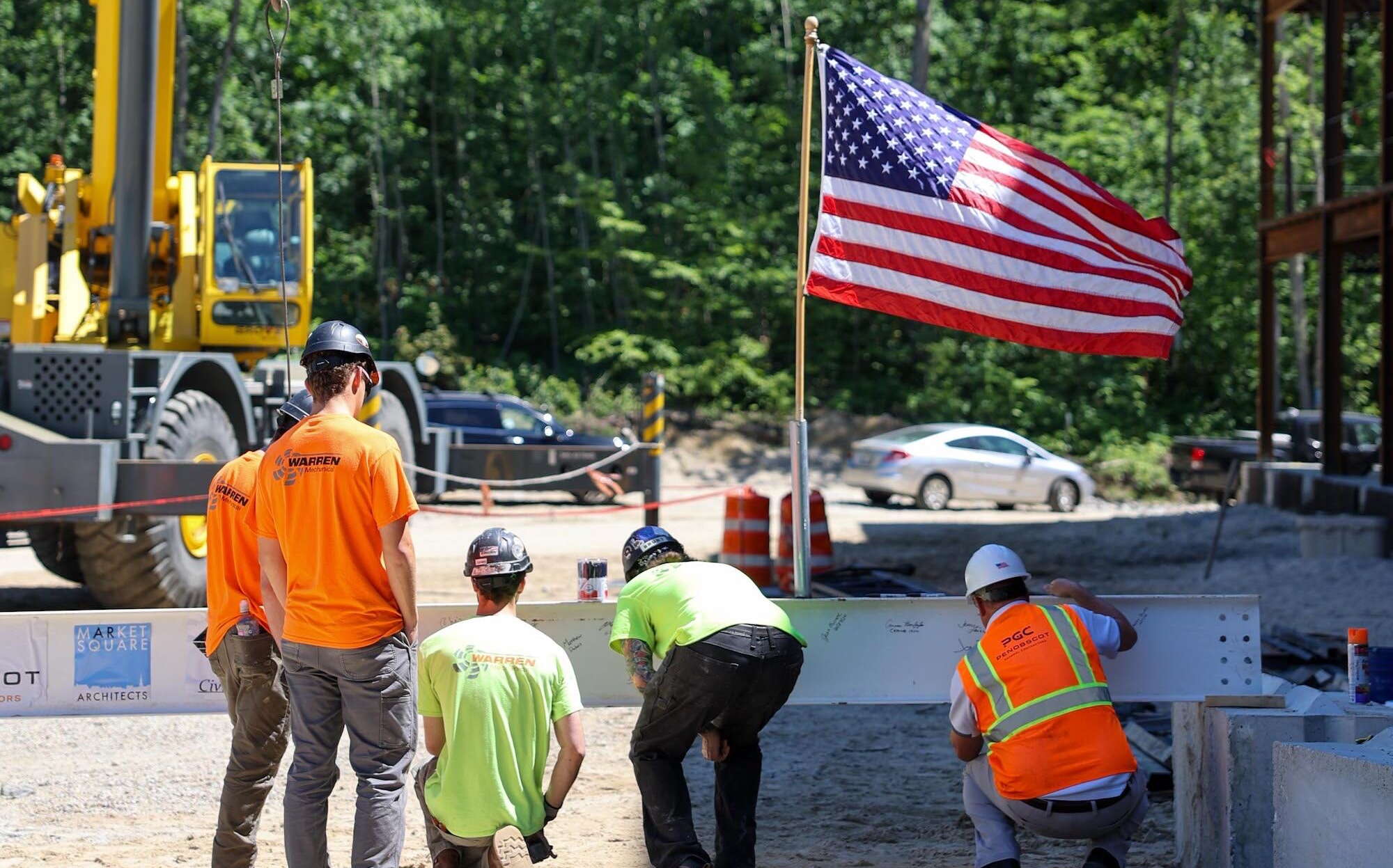 5 people prepare a beam to be lifted up at 60 Barra Road.