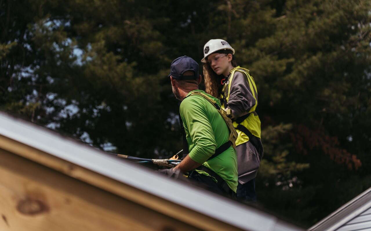 Two people on the roof are part of a training session.