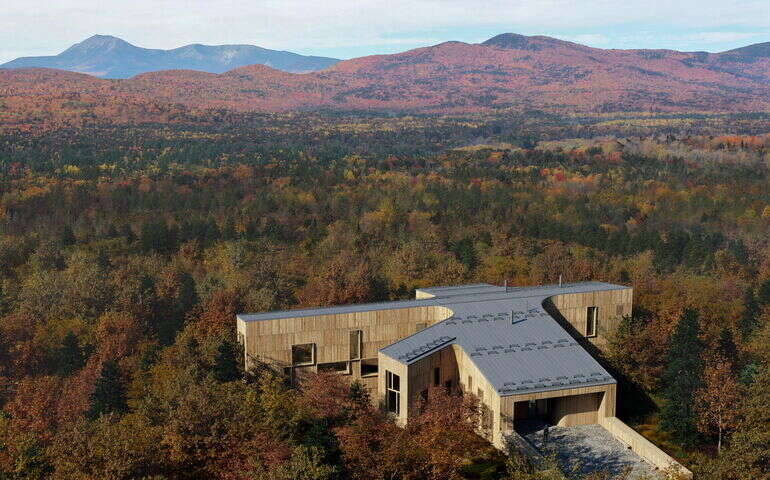 An aerial shows a rendering of a building within some woods.