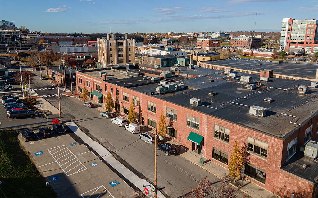 An aerial view shows a long low brick building.