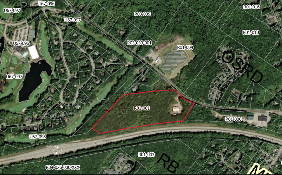 An aerial view shows woods and structures annotated.