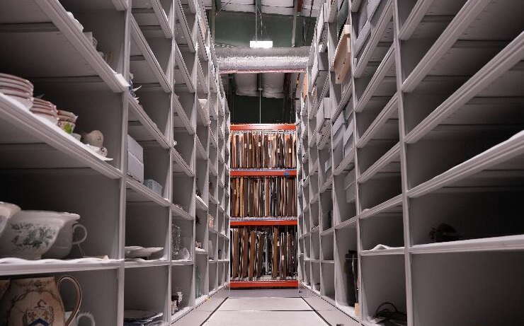 Shelves stand in an aisle.