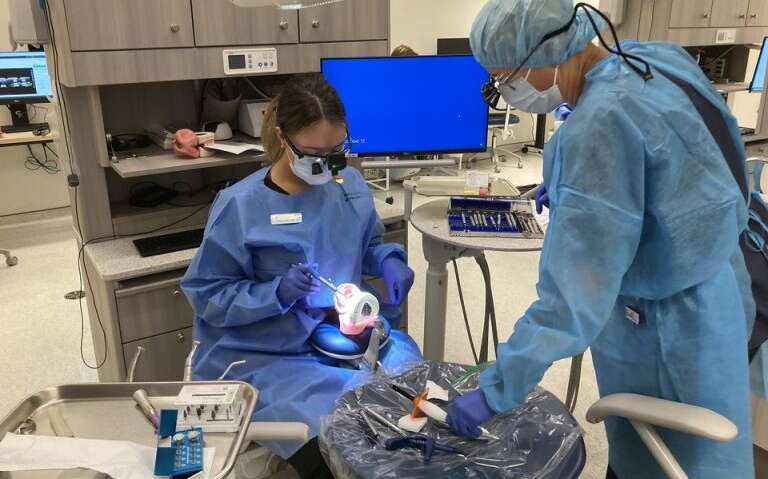 Two people work in a dentist's office.