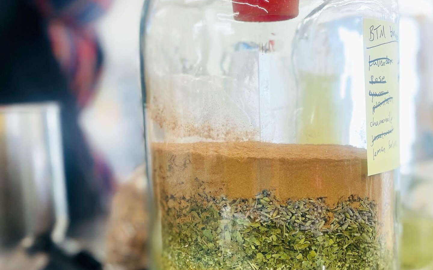 A jar contains herbs and other ingredients.