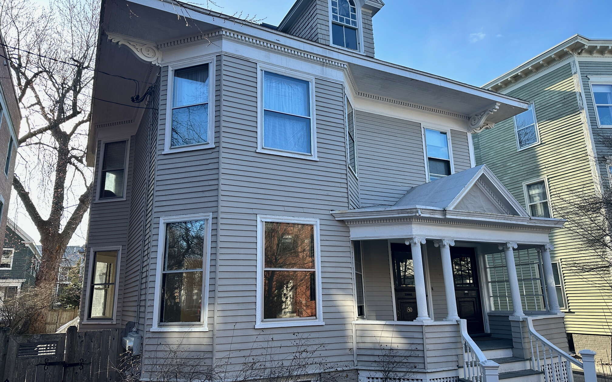 Exterior of a gray-sided house with white trim.