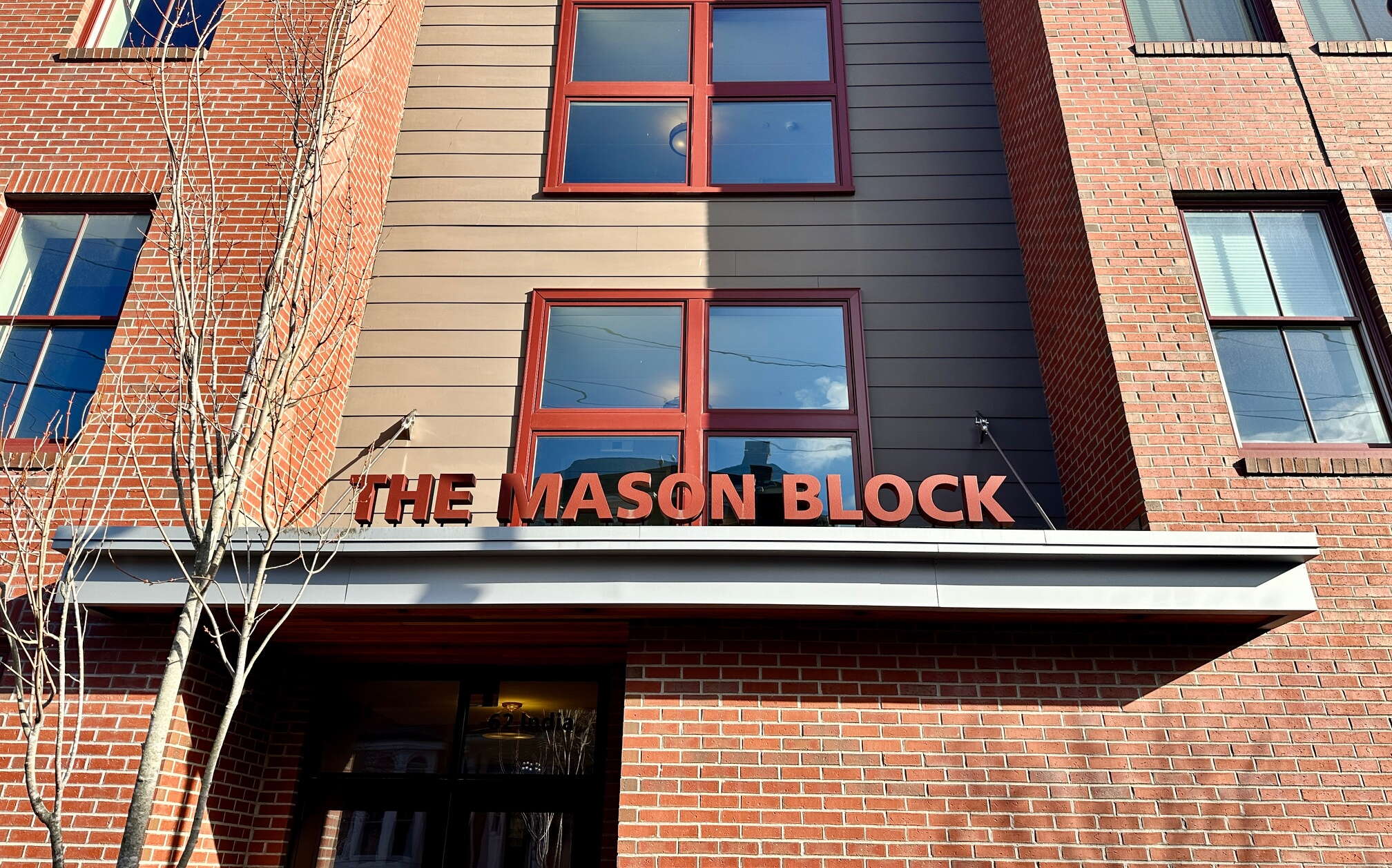 Exterior entryway of a brick building with signage.