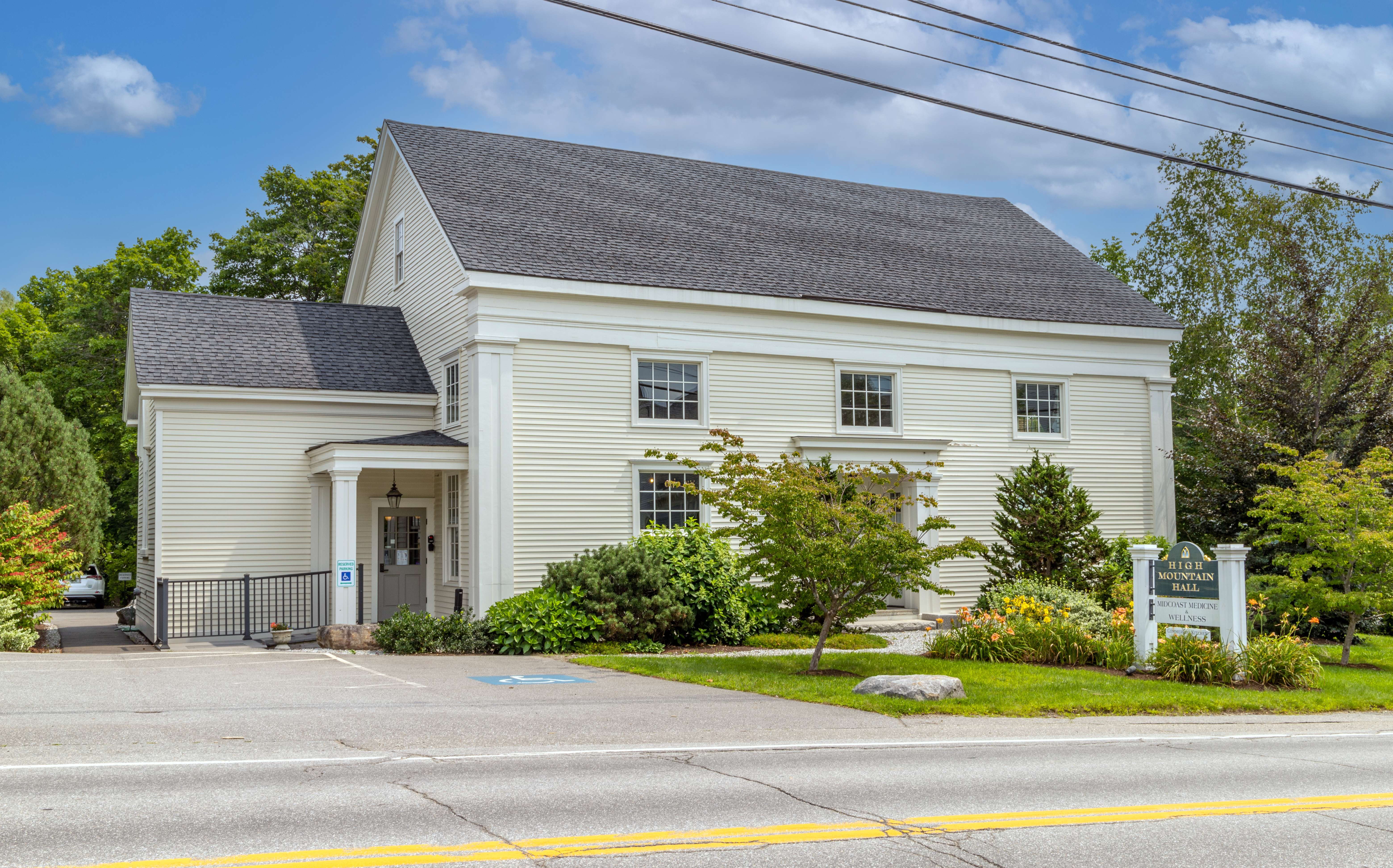 Exterior view of an old building with pale yellow siding.