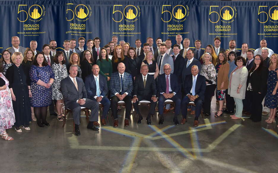 A group of stand or sit in rows for a group photo.