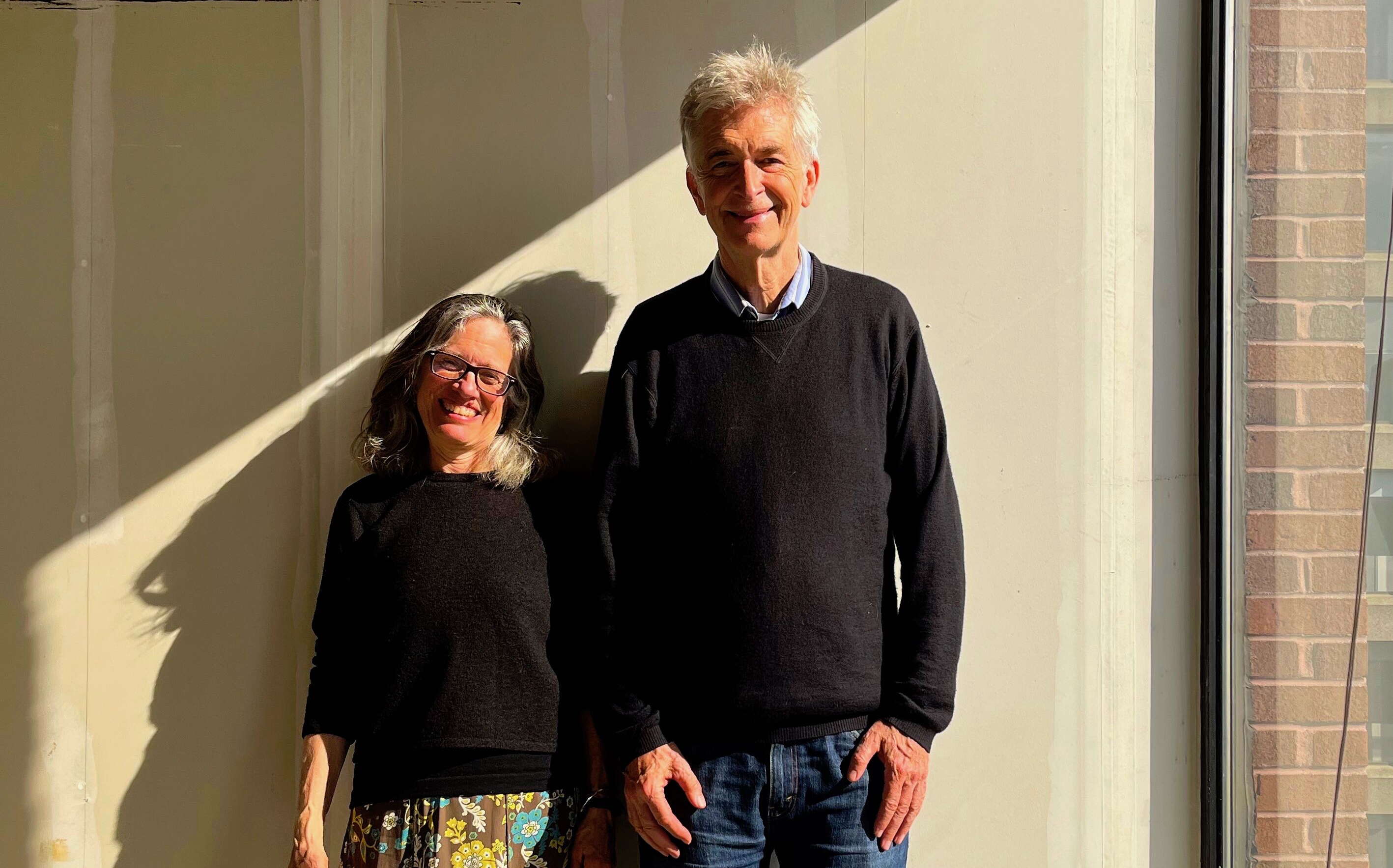 Two people stand in a room.