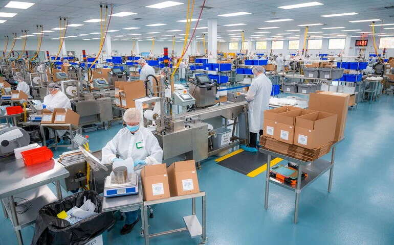 People stand in a large room working on products.