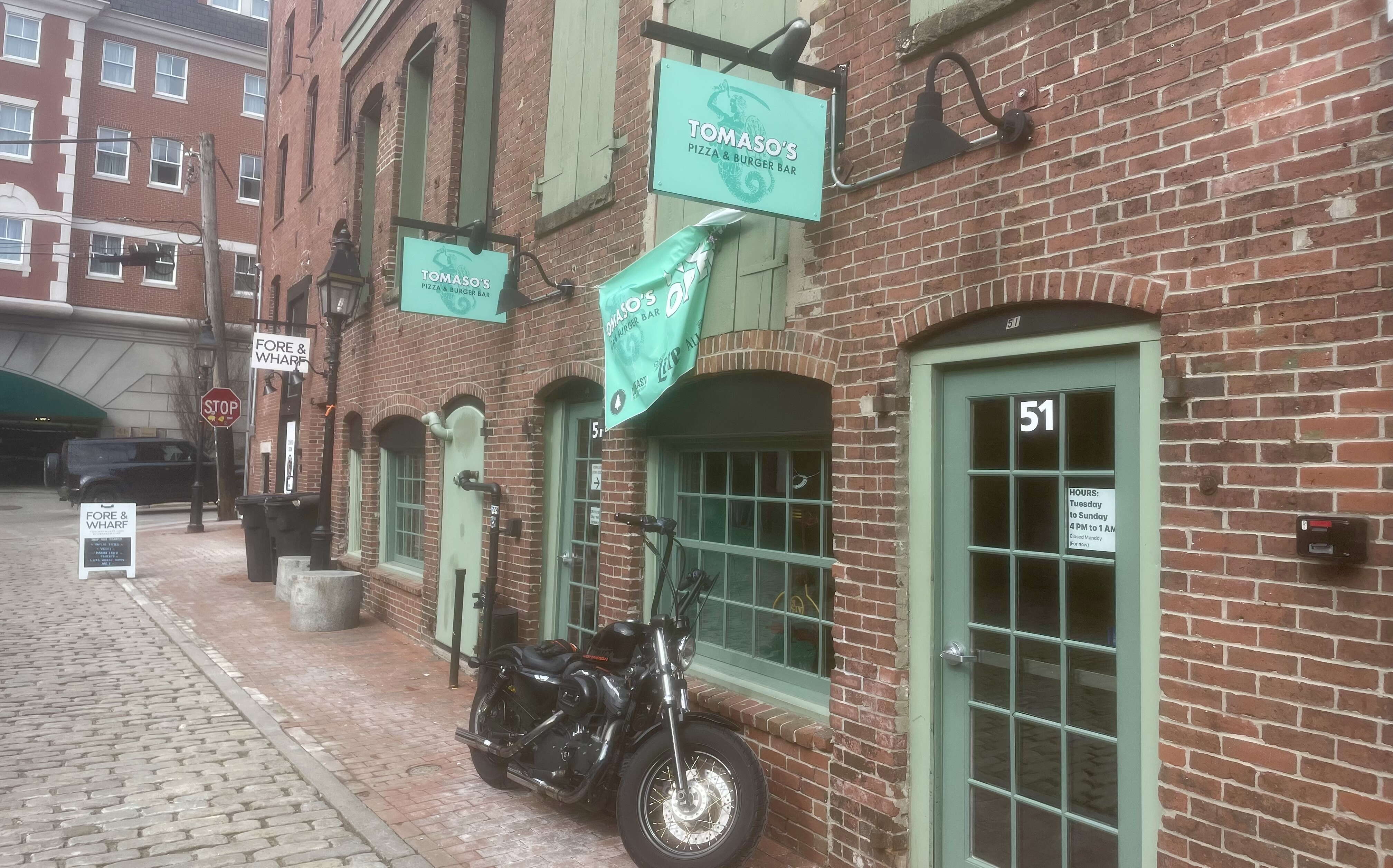 An exterior view of a brick building with green trim.