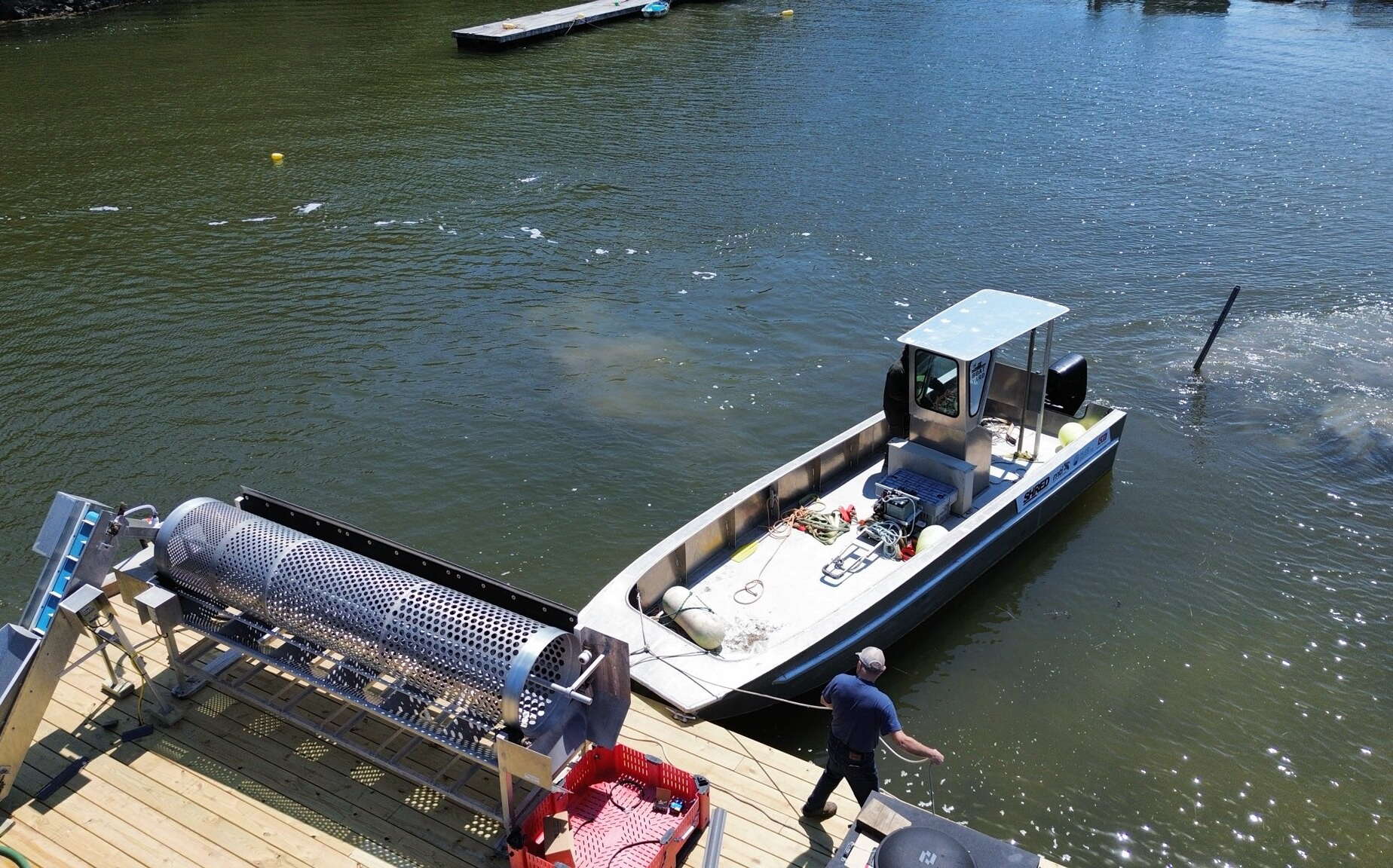 A metal boat is next to a dock.