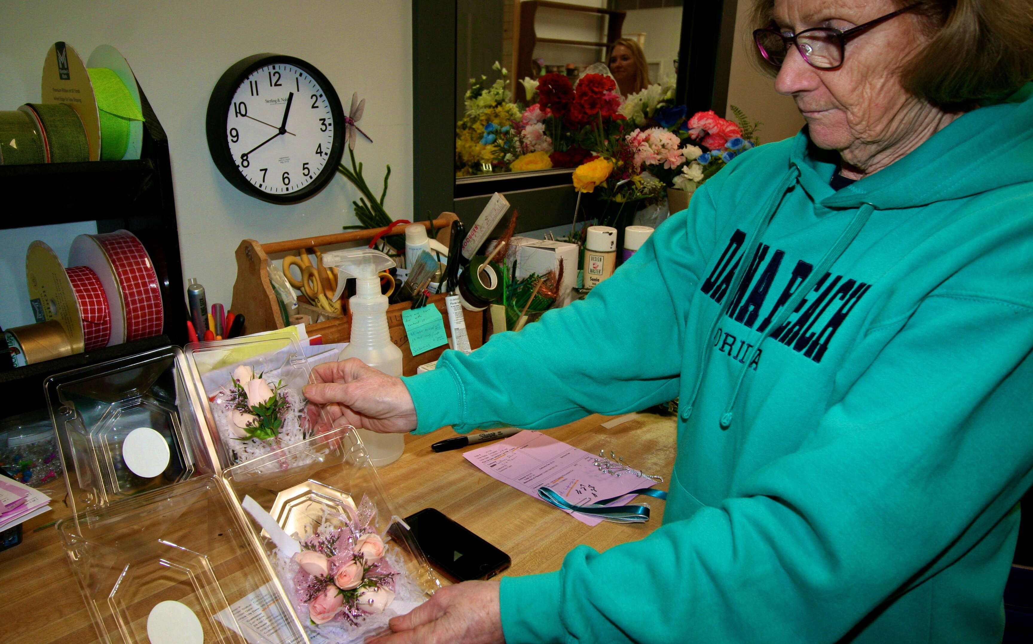 A persn holds a plastic box with flowers.