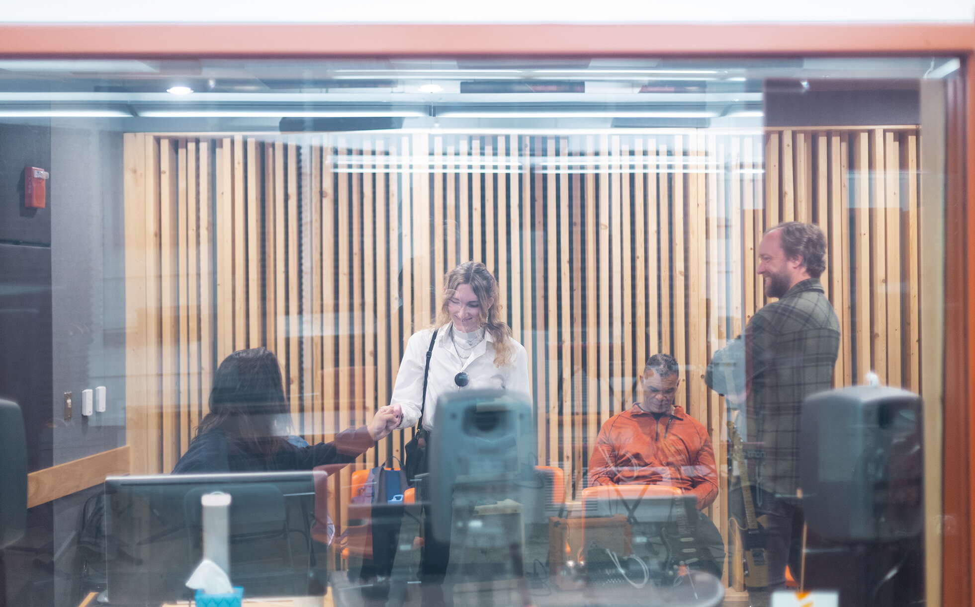 Four people are seen through a pane of glass.