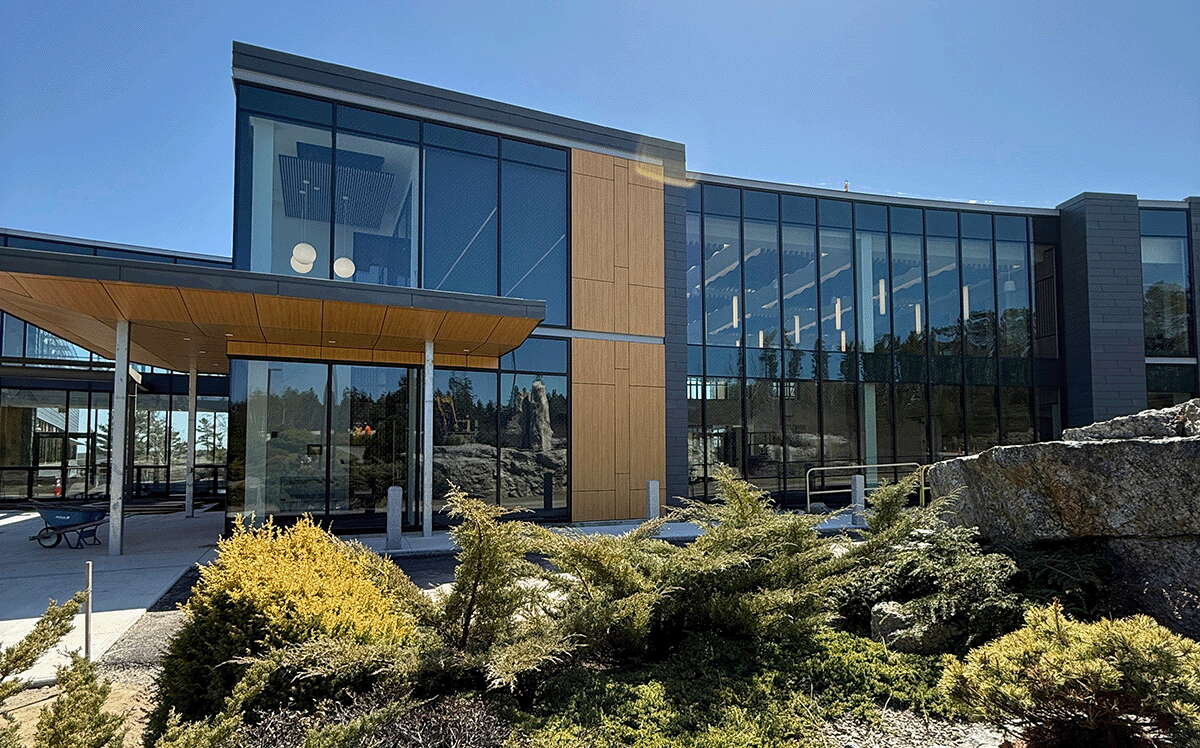 An exterior view of a building shows lots of big windows.
