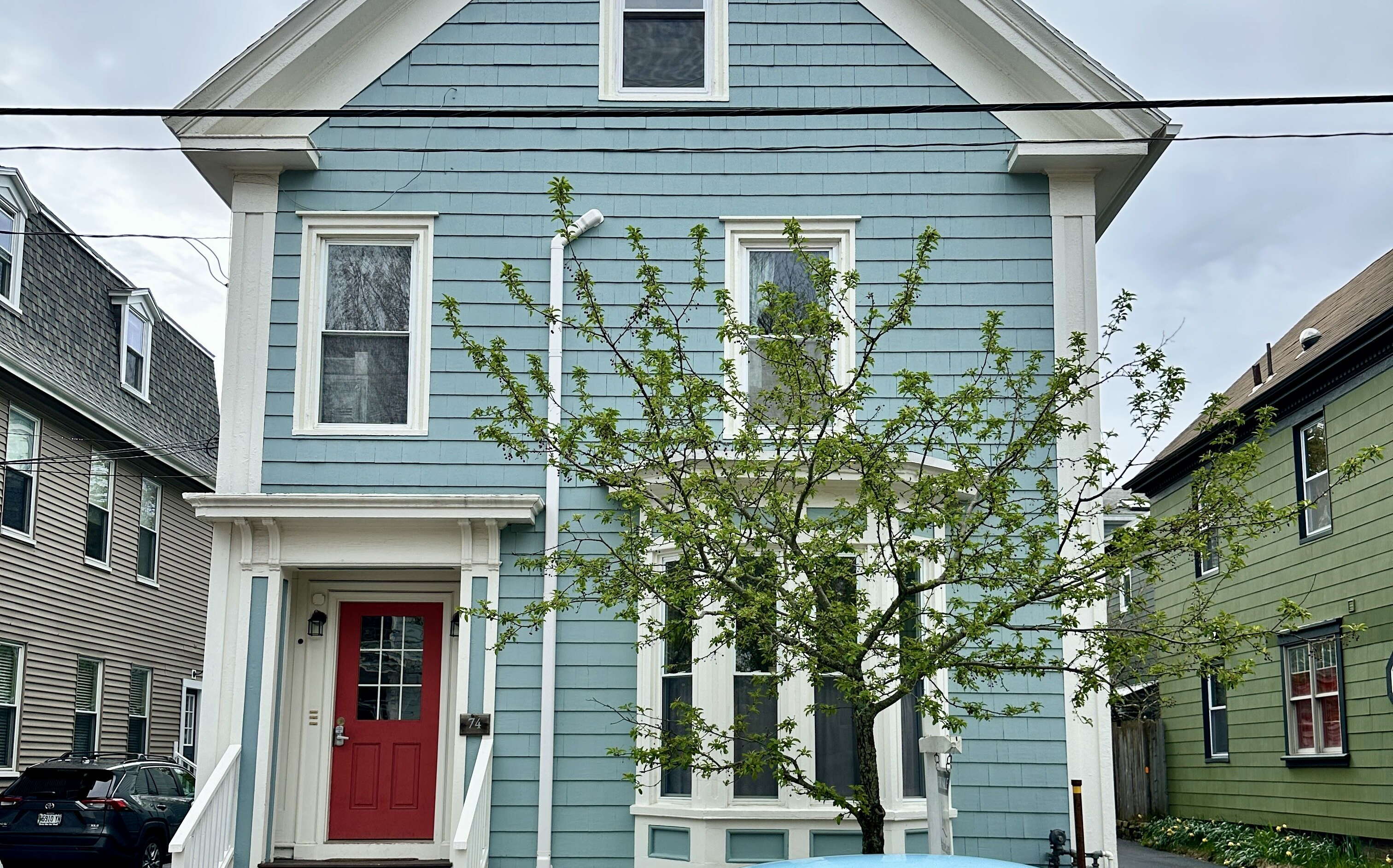 A blue-sided house as a blue VW outside.