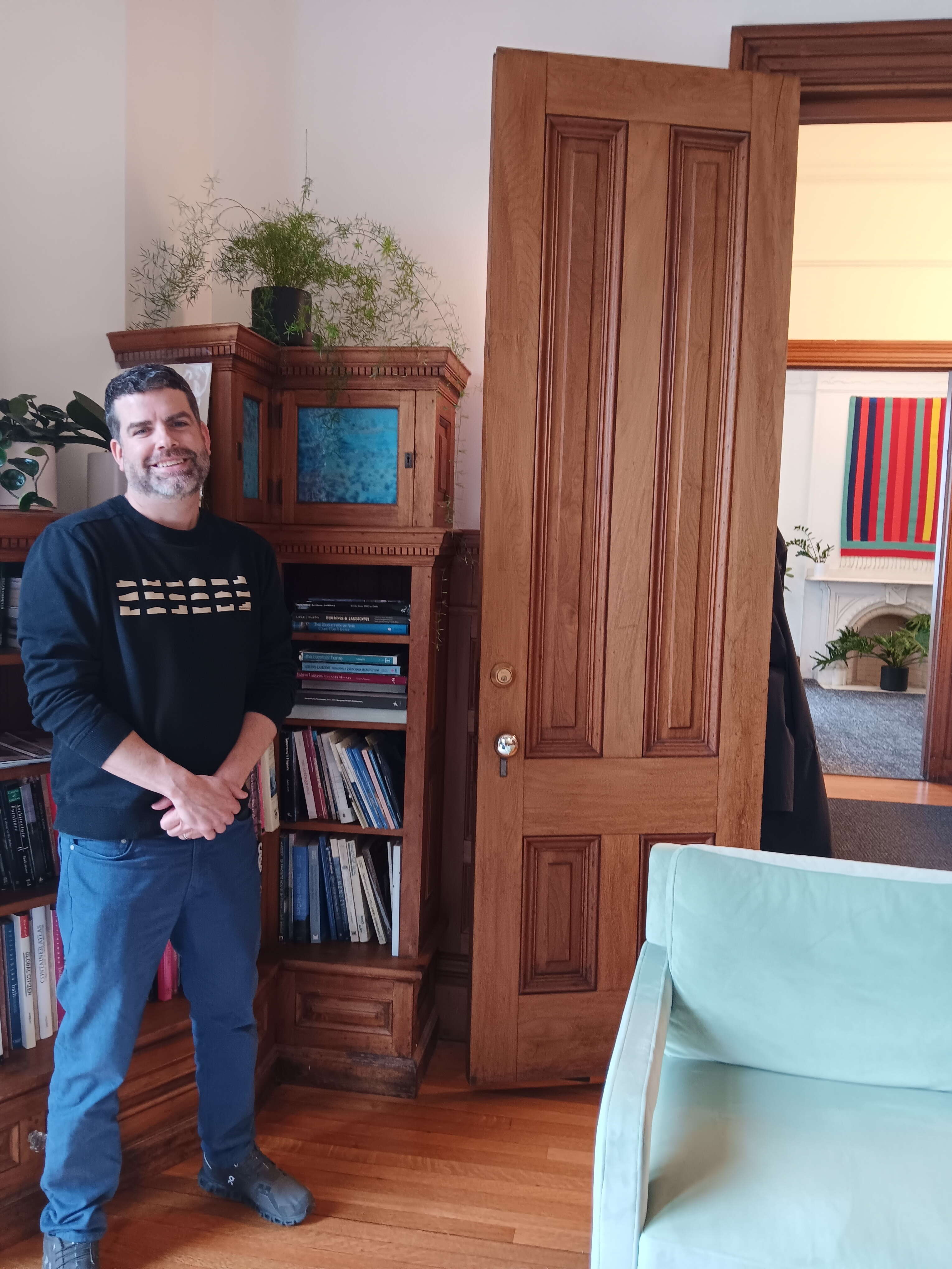 man stands in front of bookcase
